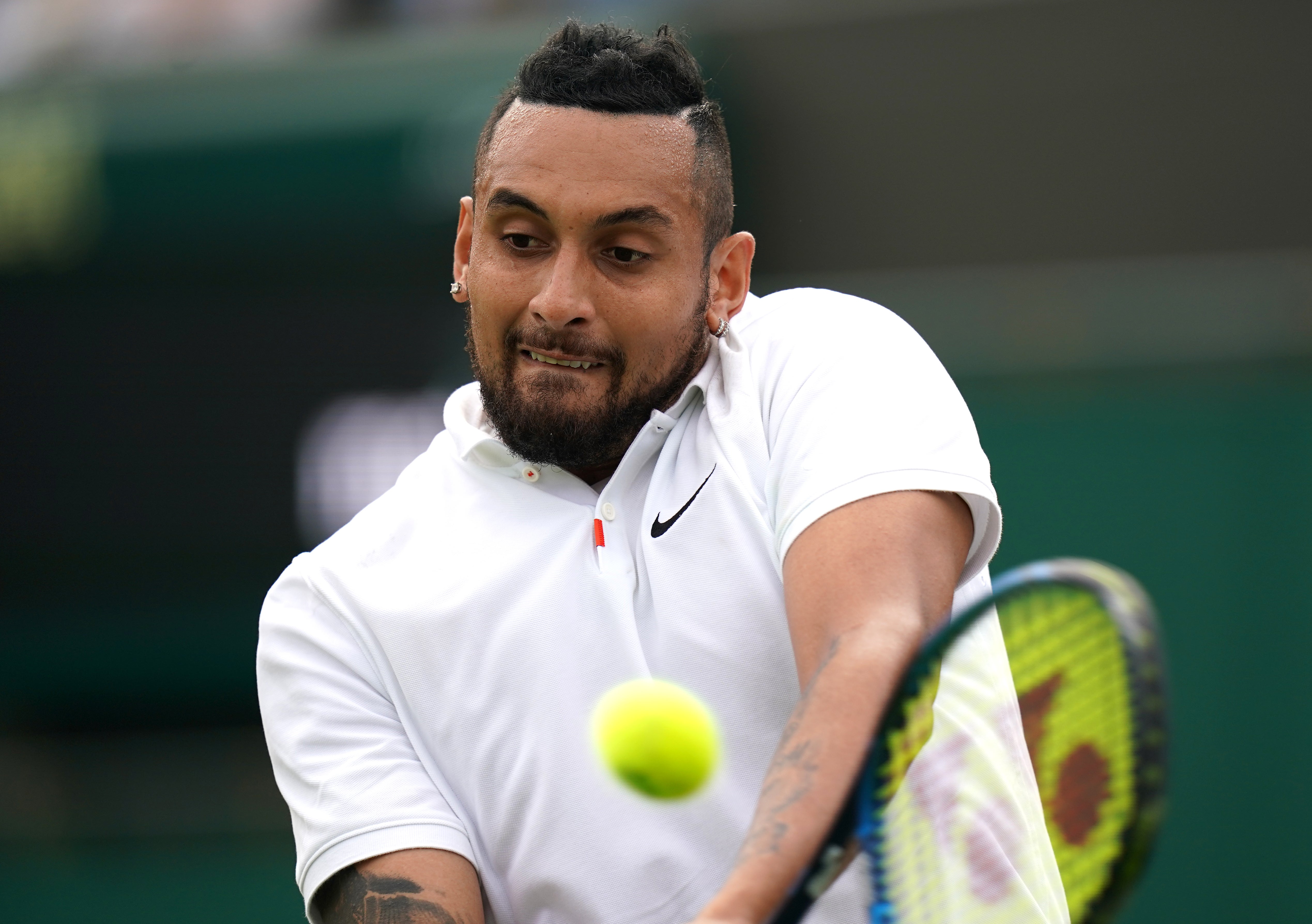 Nick Kyrgios hitting a backhand at Wimbledon