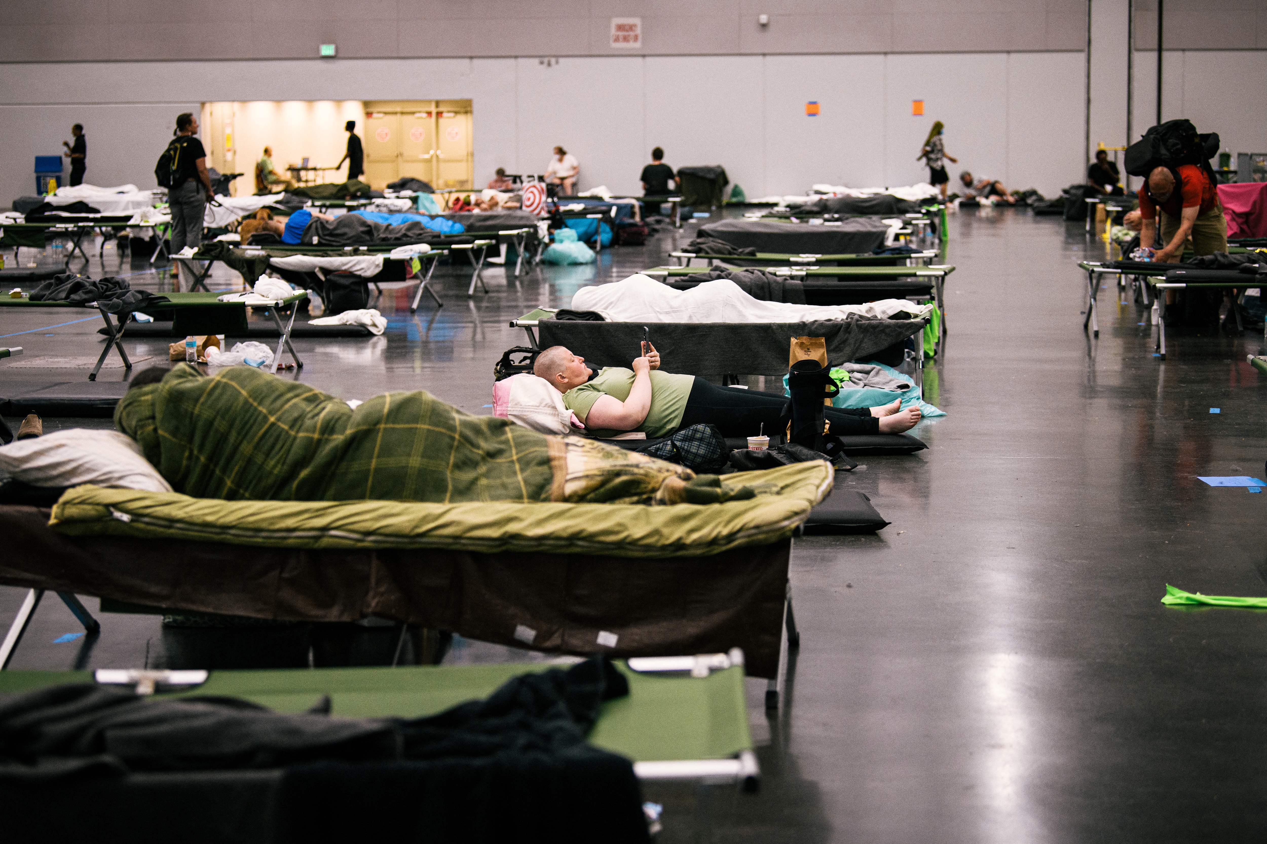 People rest at the Oregon Convention Center ‘cooling station’ during last month’s record heat