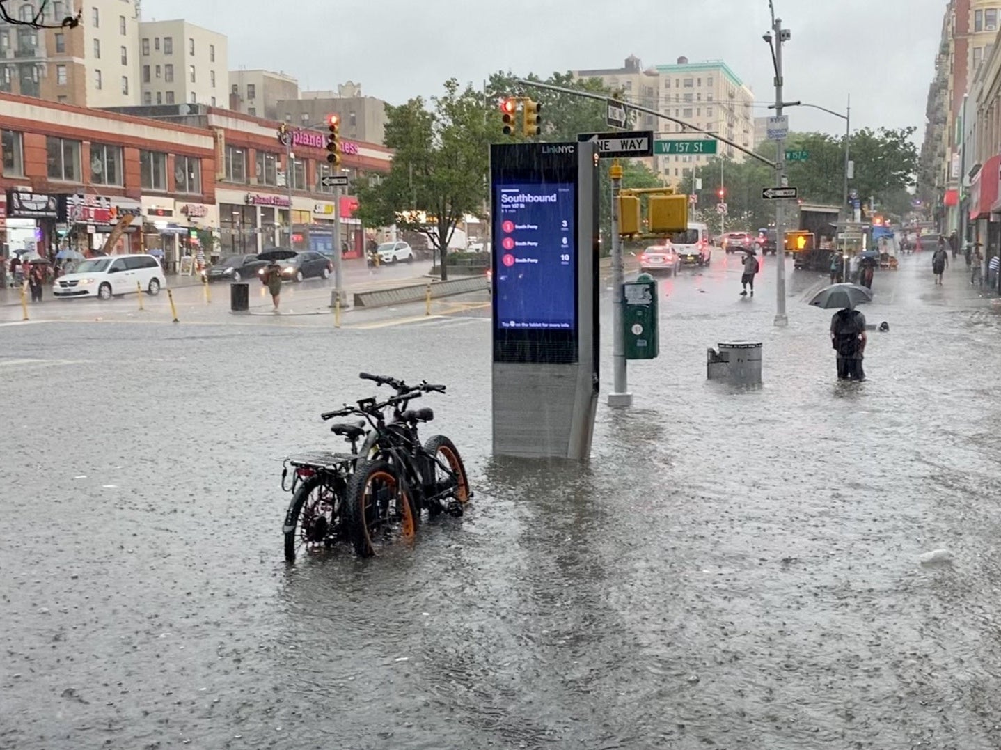 A person wades through the flood water near the 157th Street metro station