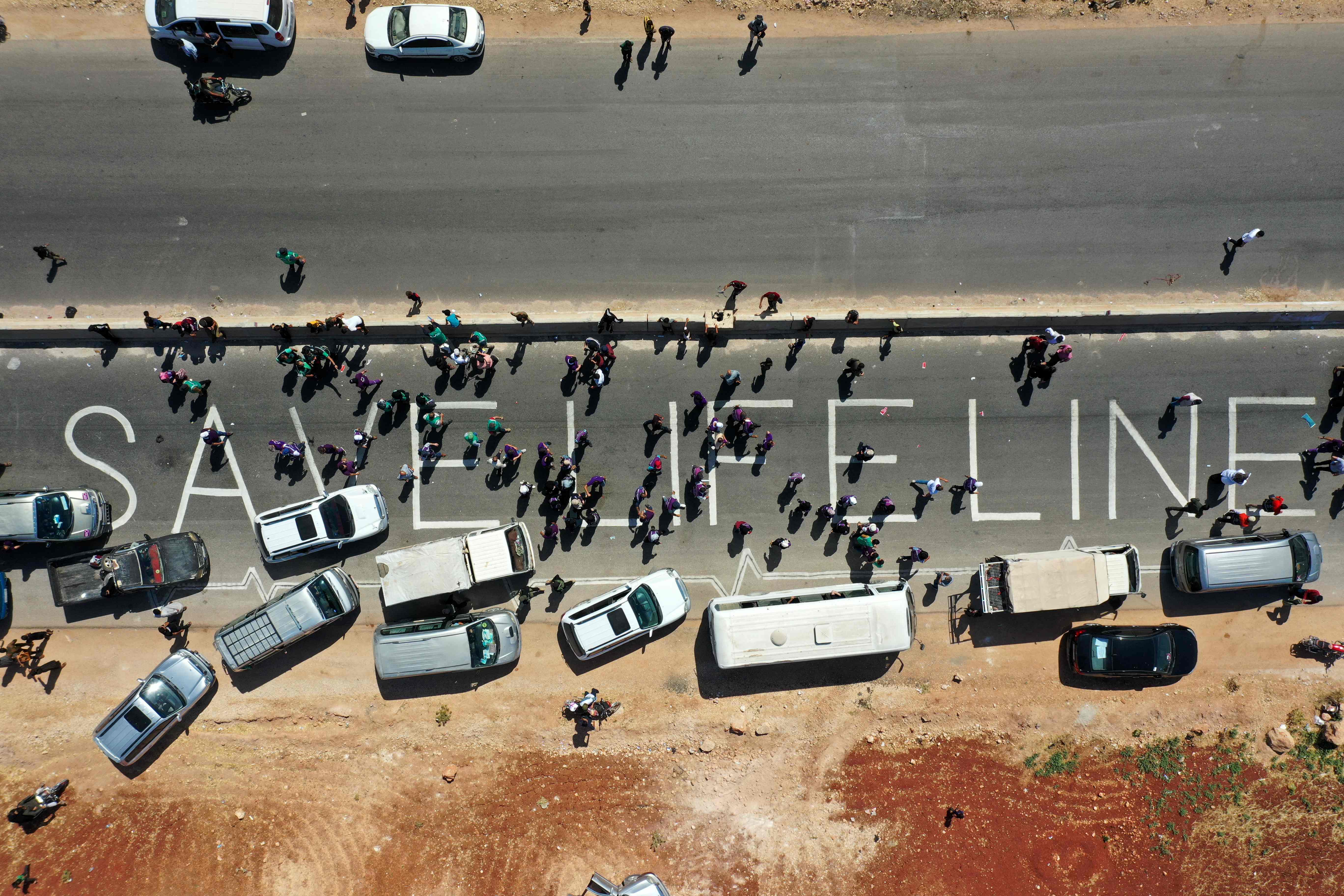 A human chain is formed by workers from the civil society, humanitarian aid, and medical and rescue services in a vigil calling for maintaining a UN resolution authorising the passage of humanitarian aid into Syria's rebel-held northwestern province