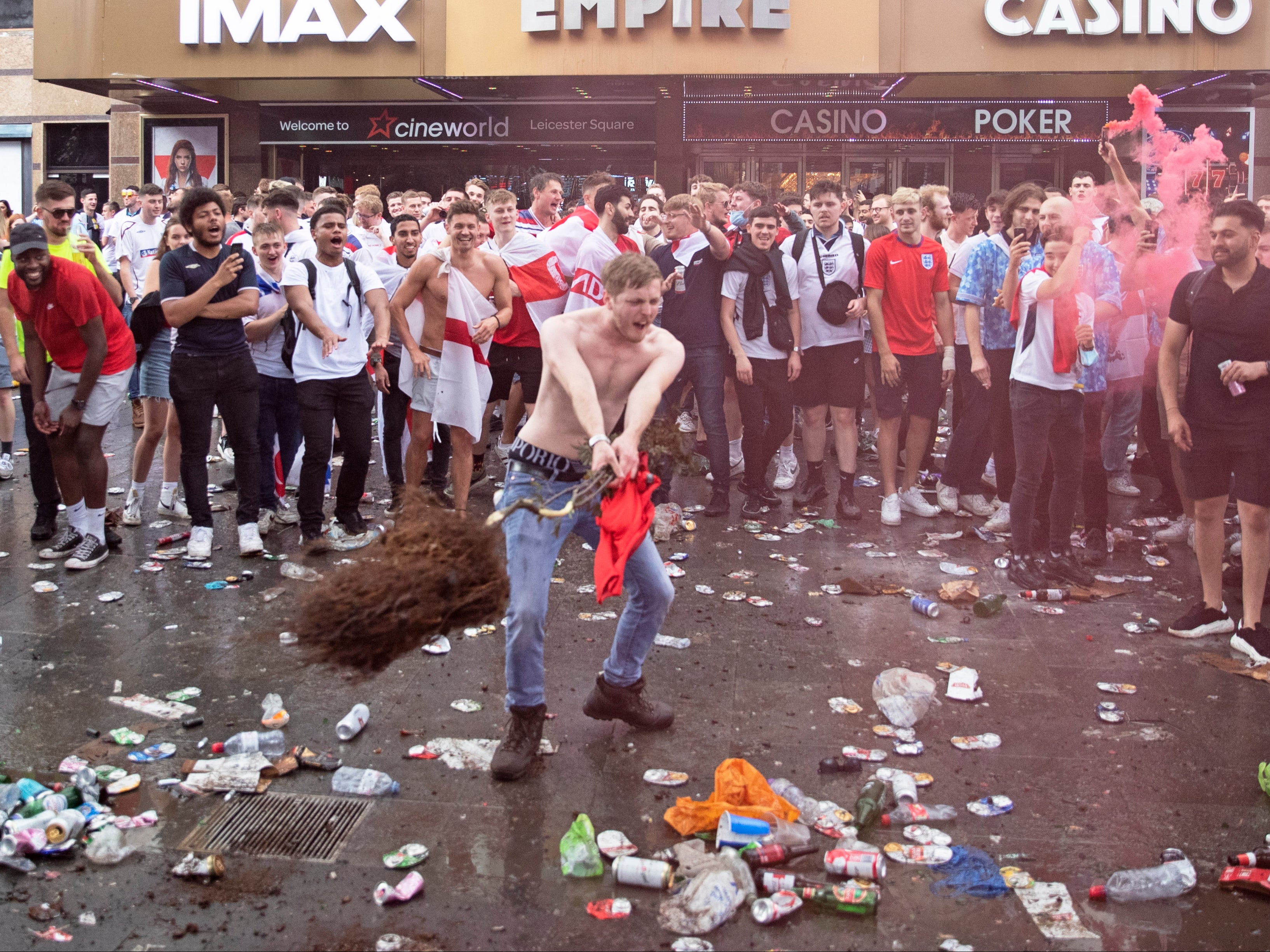 A fan throws a decorative tree which has been uprooted from Leicester Square