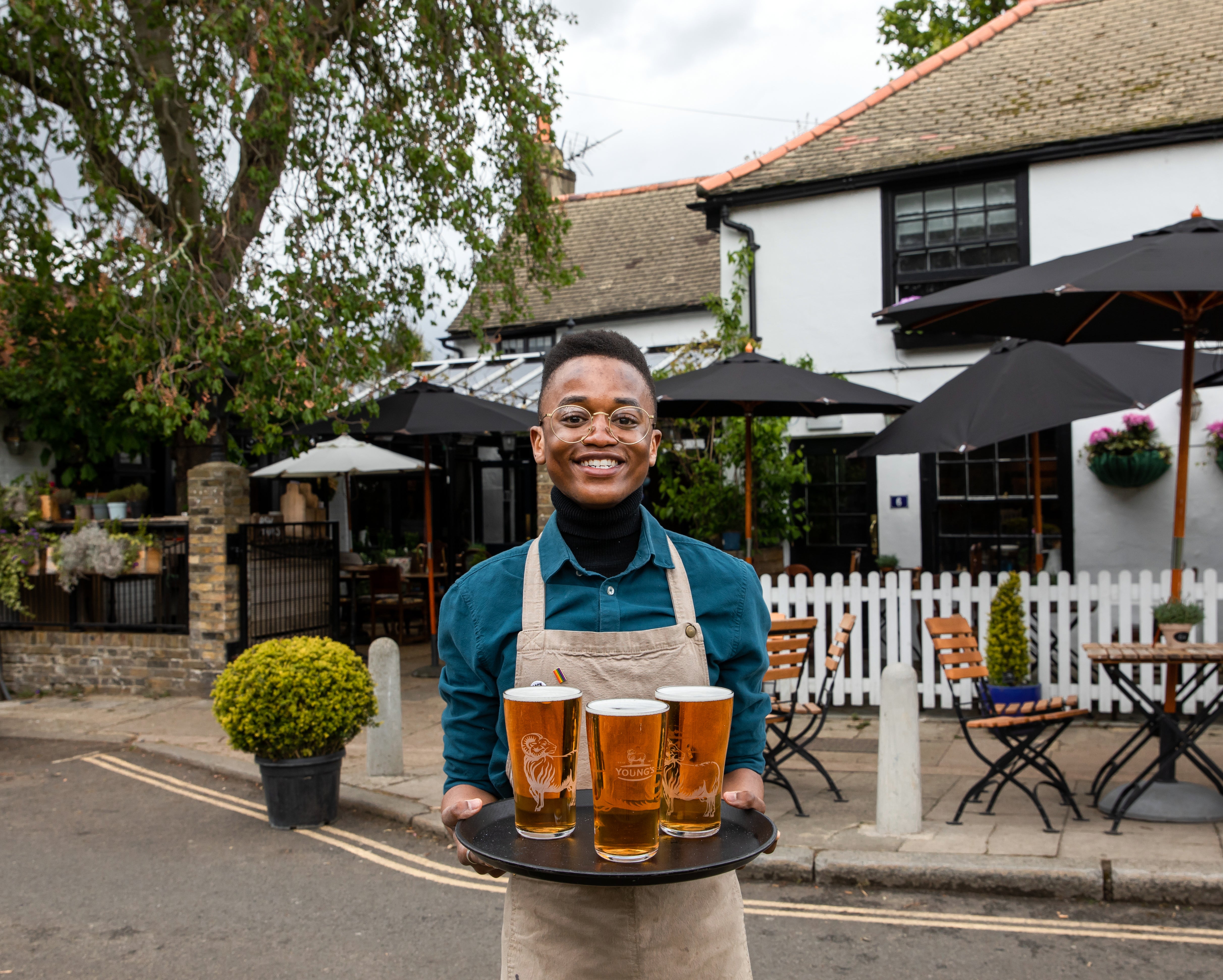 A barman carries a tray of drinks