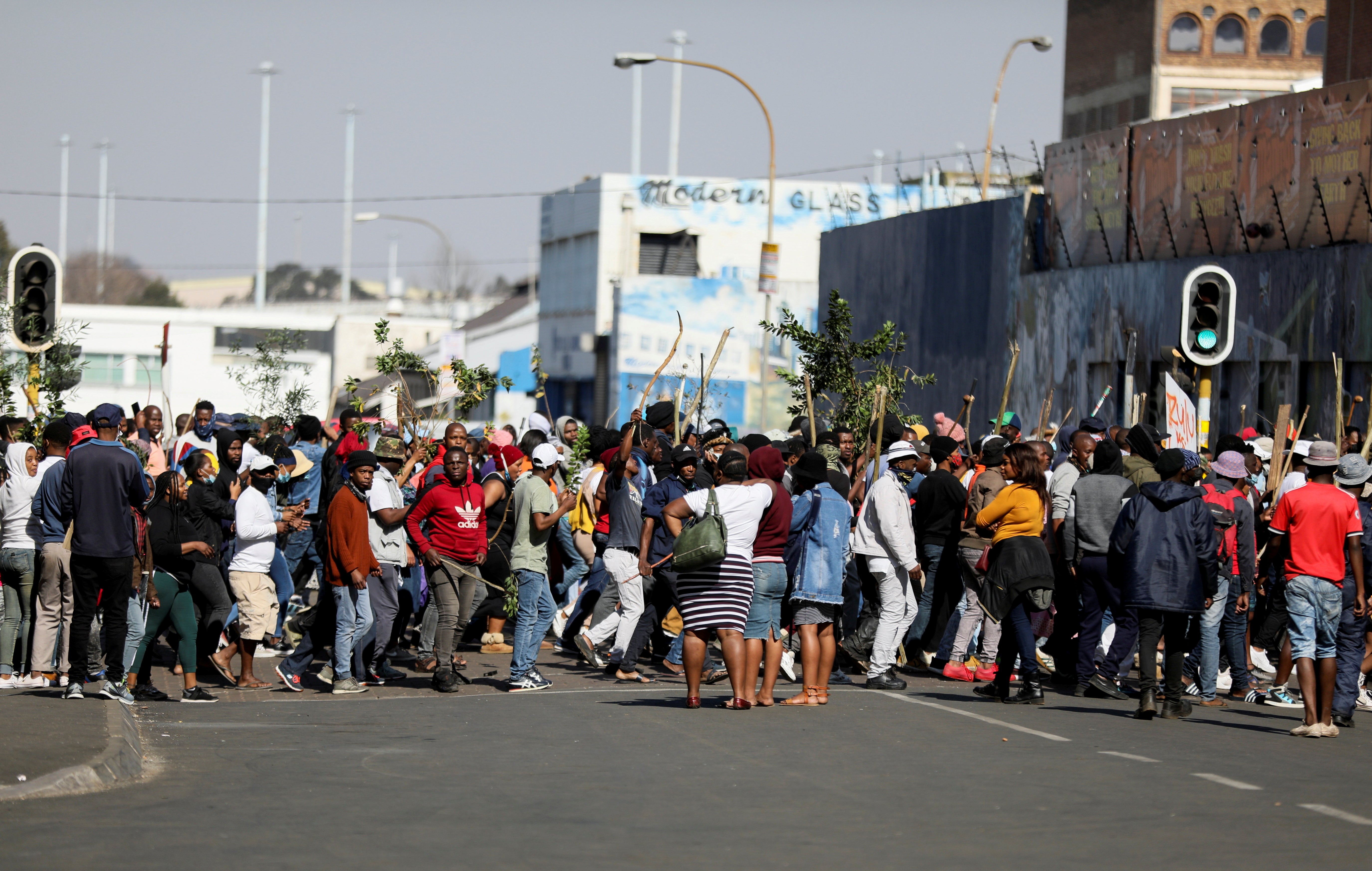 Stick-wielding protesters march through the streets of Johannesburg following the imprisonment of former South African President Jacob Zuma