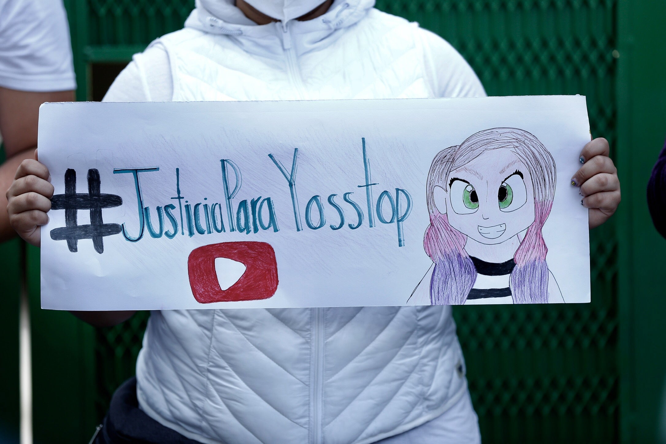 A supporter of YosStop holds a poster in her support at the court