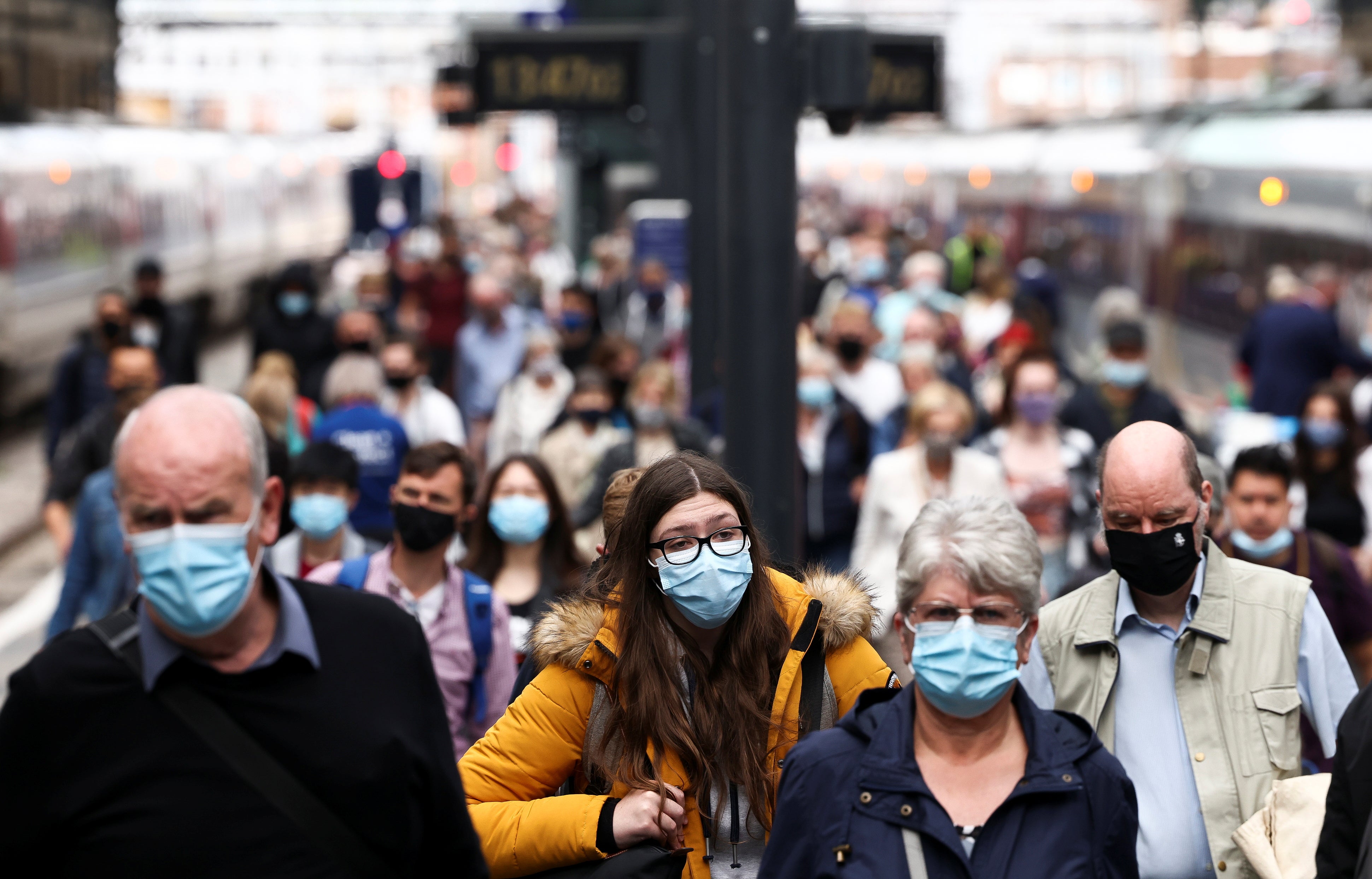 Post-Covid commute: People wearing protective face masks walk along a platform at King's Cross Station