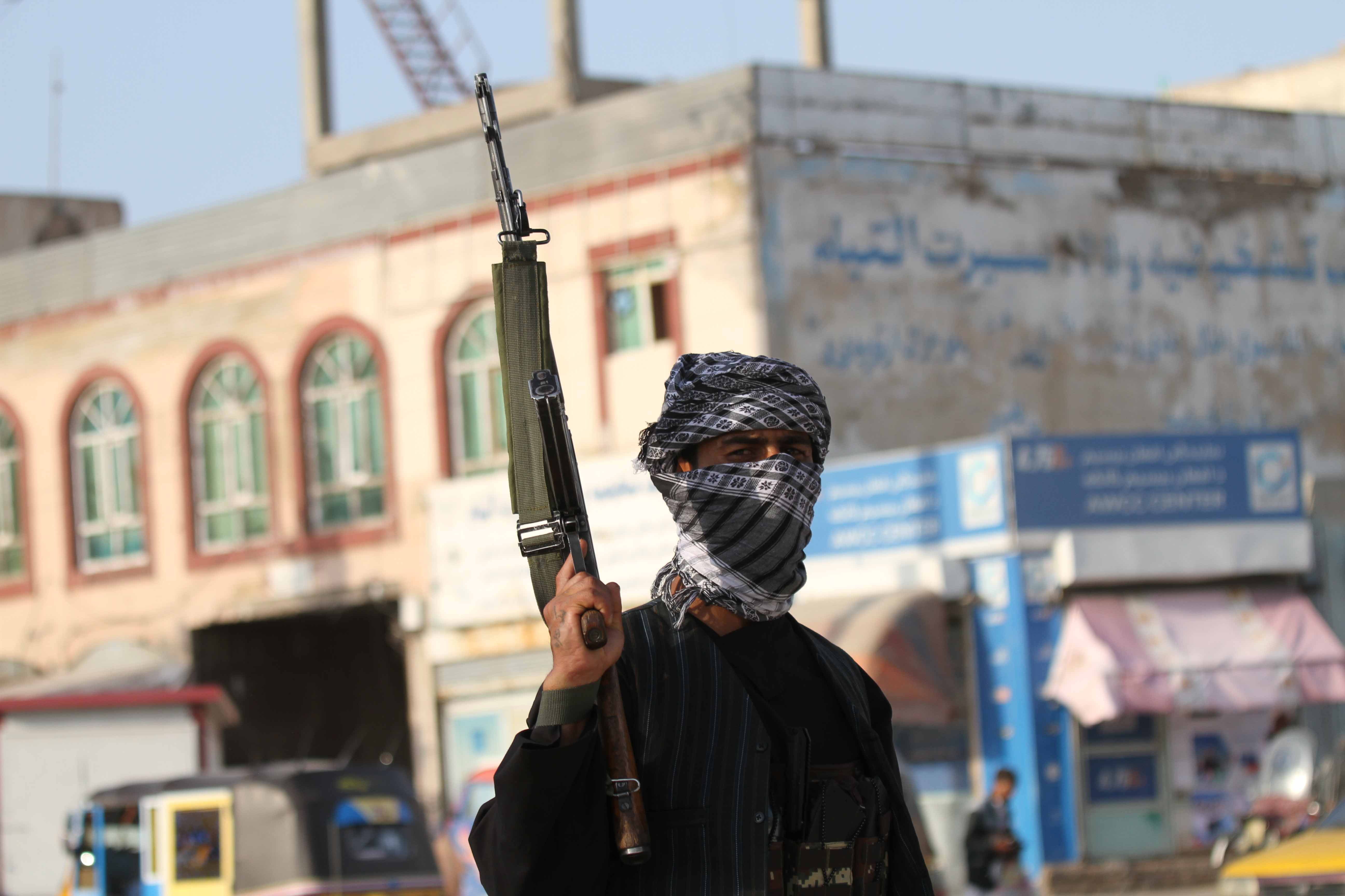 Armed supporters of former Mujahideen commander Khan, stand guard on a roadside checkpoint as they vow to fight side by side with the Afghan security forces to defend their regions