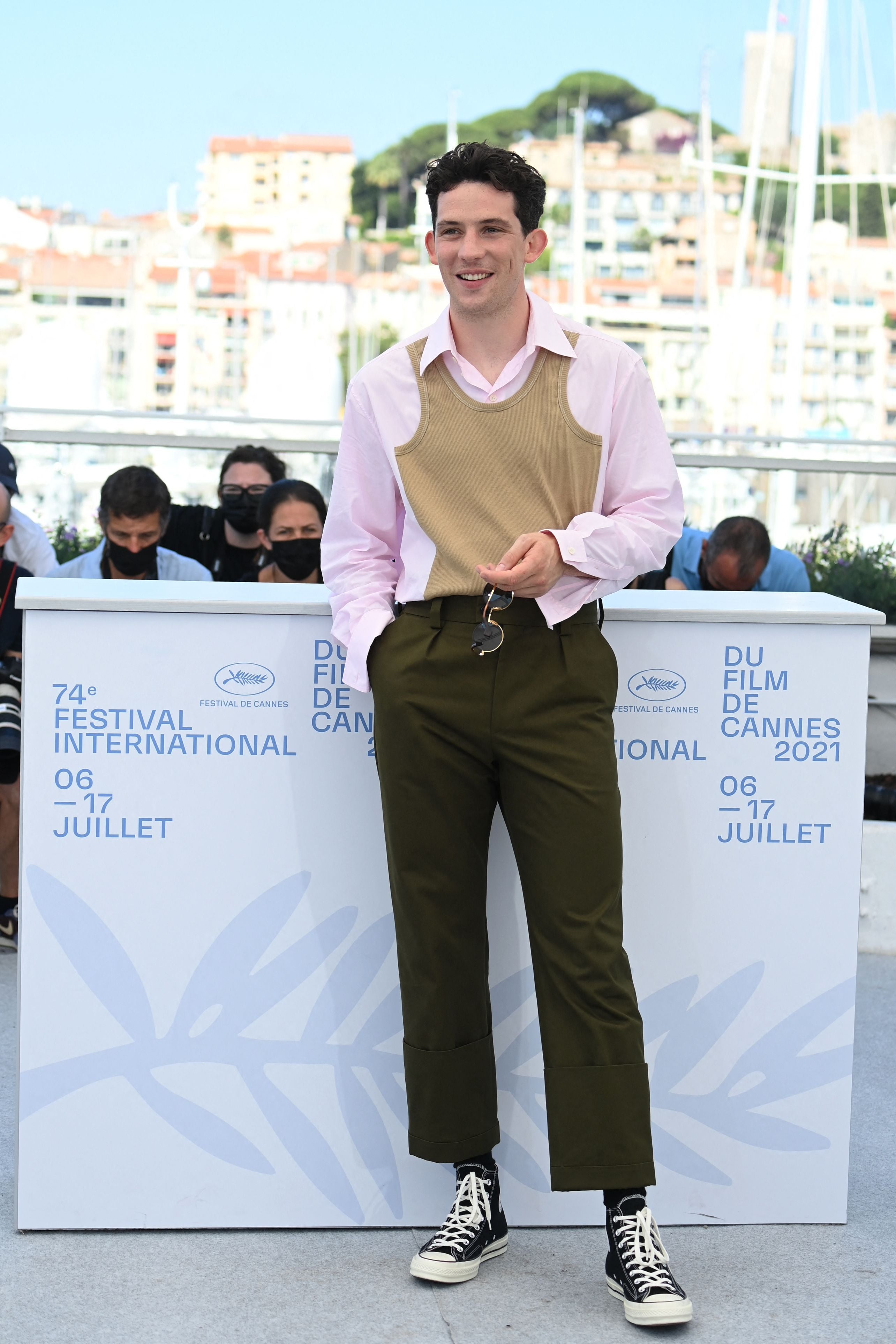 The British actor, best known for playing Prince Charles in The Crown, wore a simple tailored look by Loewe for a photocall at Cannes, comprising a pair of khaki trousers and a pale pink shirt with a mock beige vest over the top.