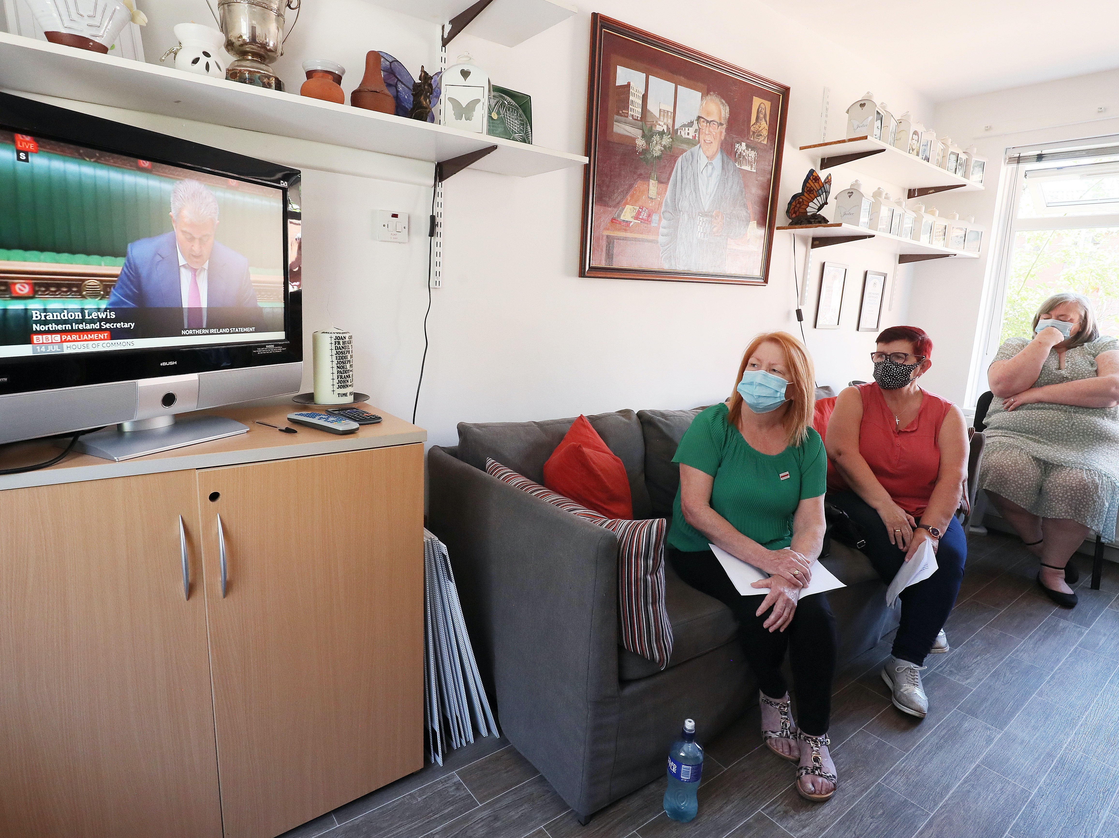 (From left) Eileen McKeown, Mary Corr and Irene Connolly, family members of Ballymurphy massacre victims, watch the Lewis statement at Springhill Community House in Belfast