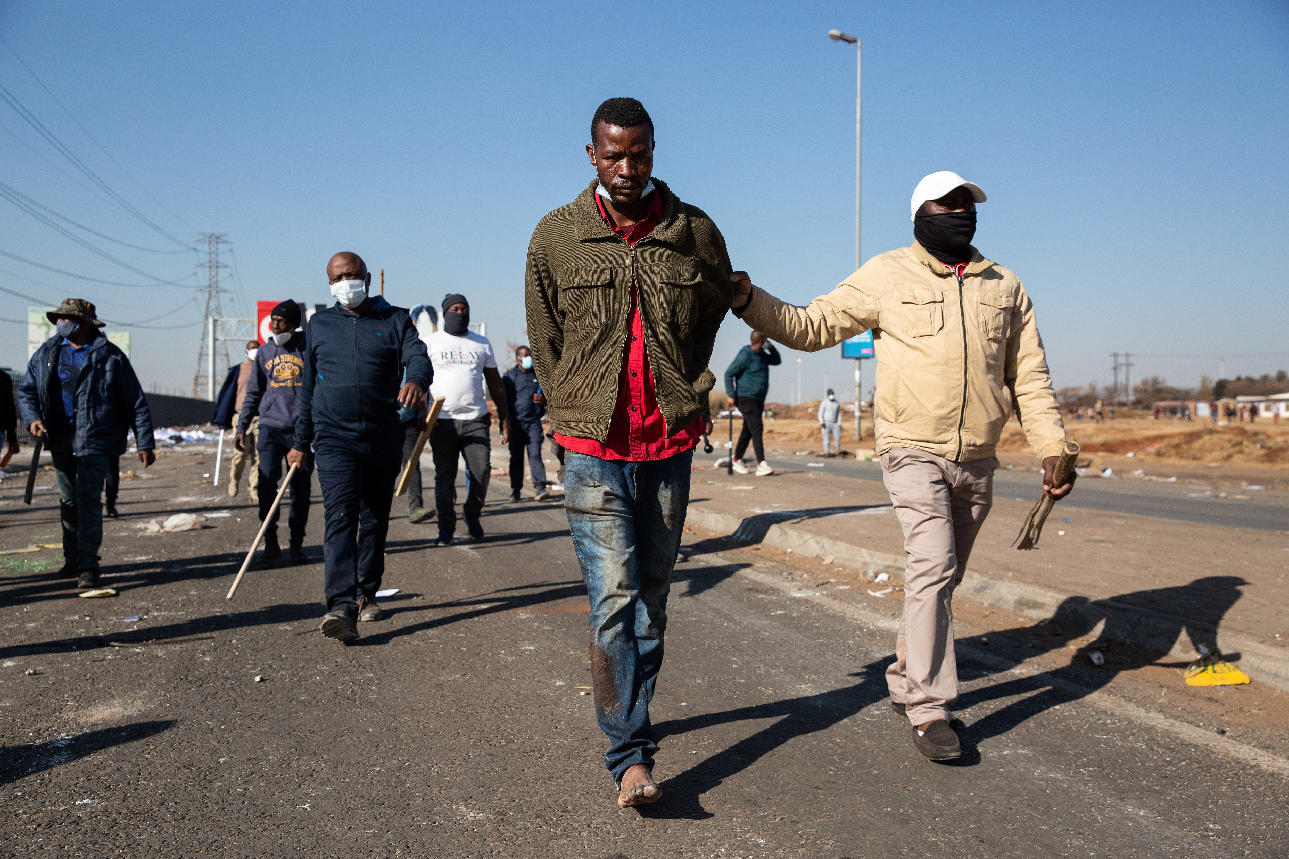 Vigilantes detain a man who they accused of looting in Vosloorus, Johannesburg