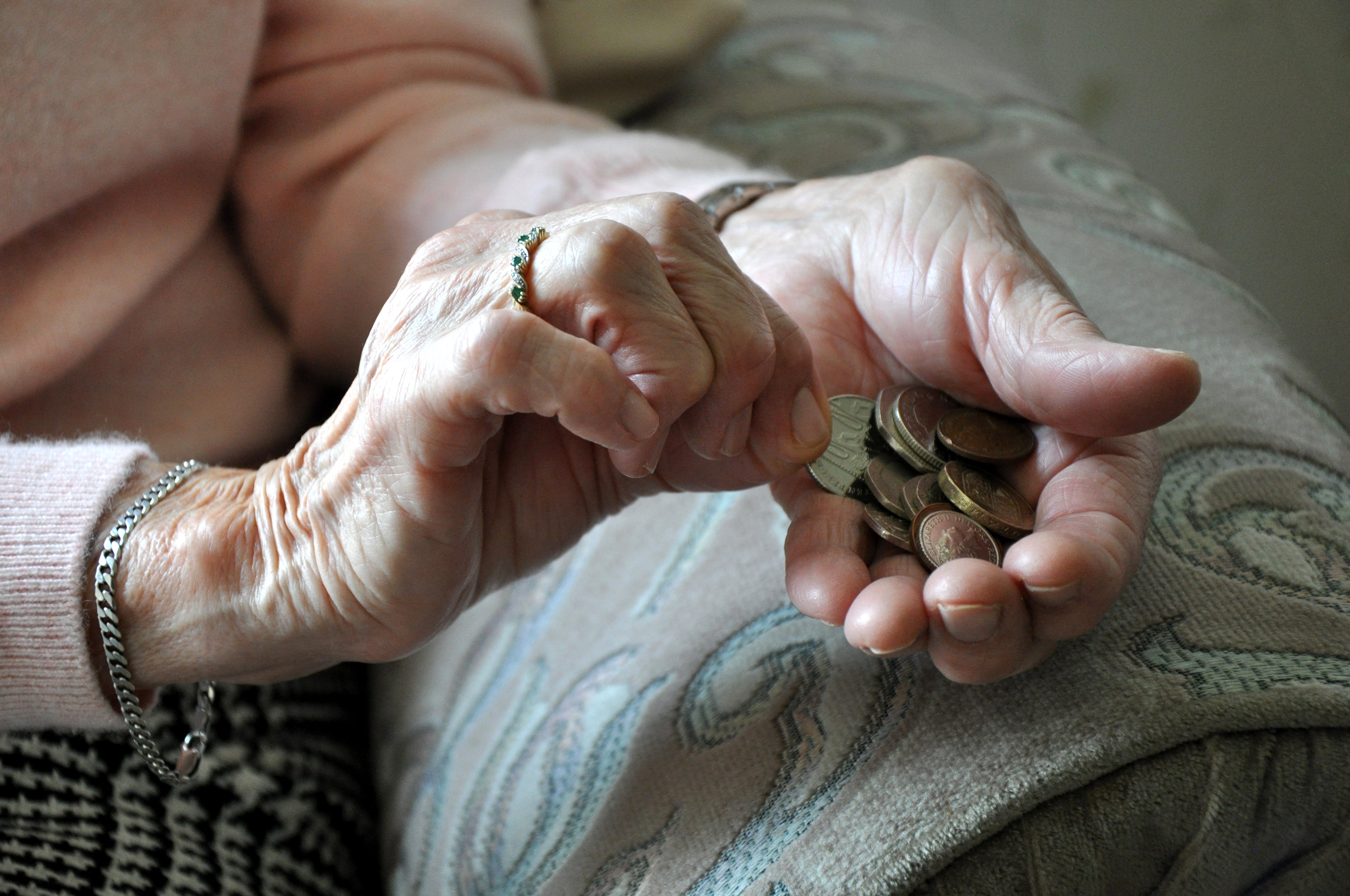 An elderly woman holding coins