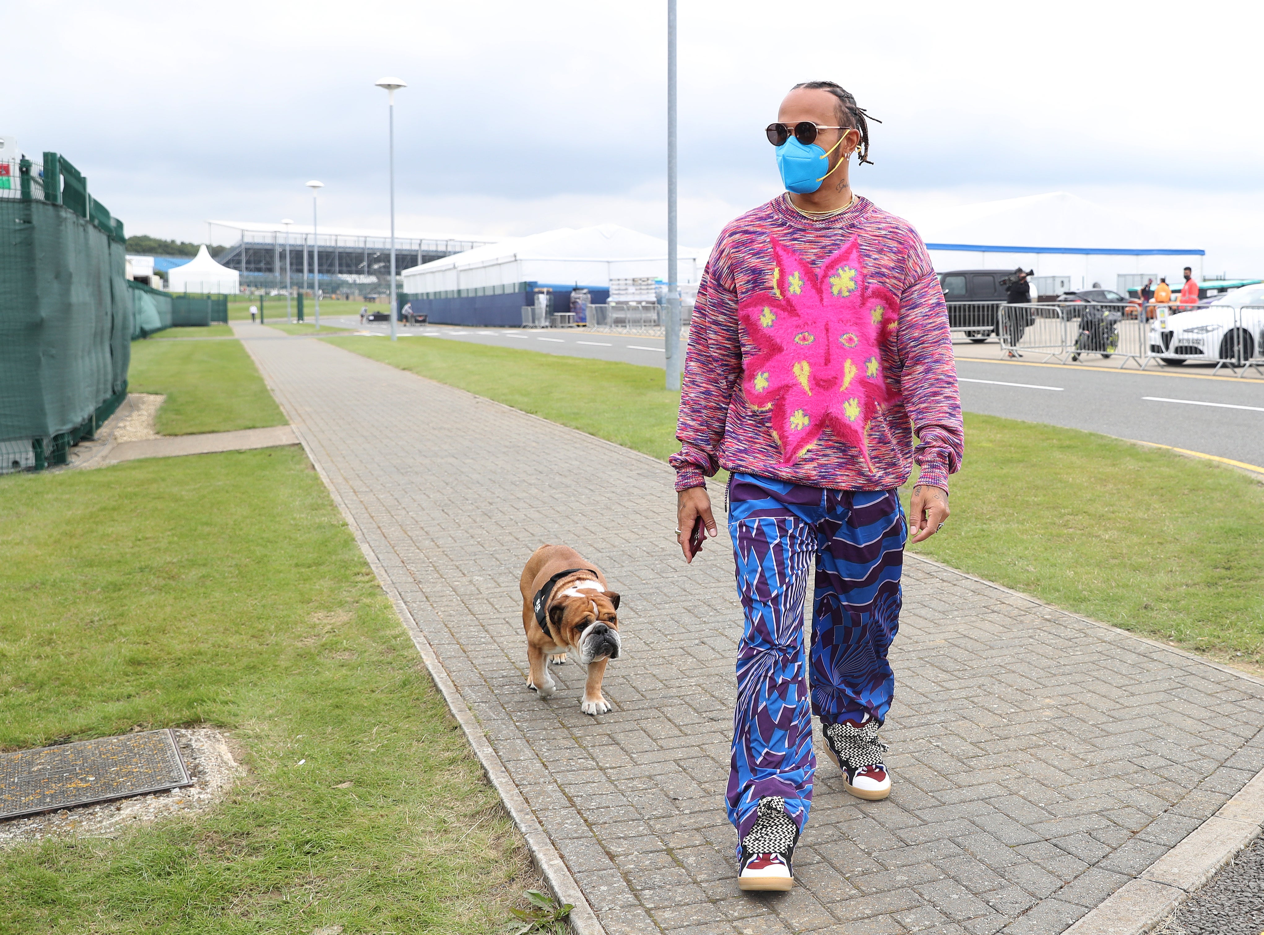 Lewis Hamilton and his dog Roscoe arrive at the paddock at Silverstone