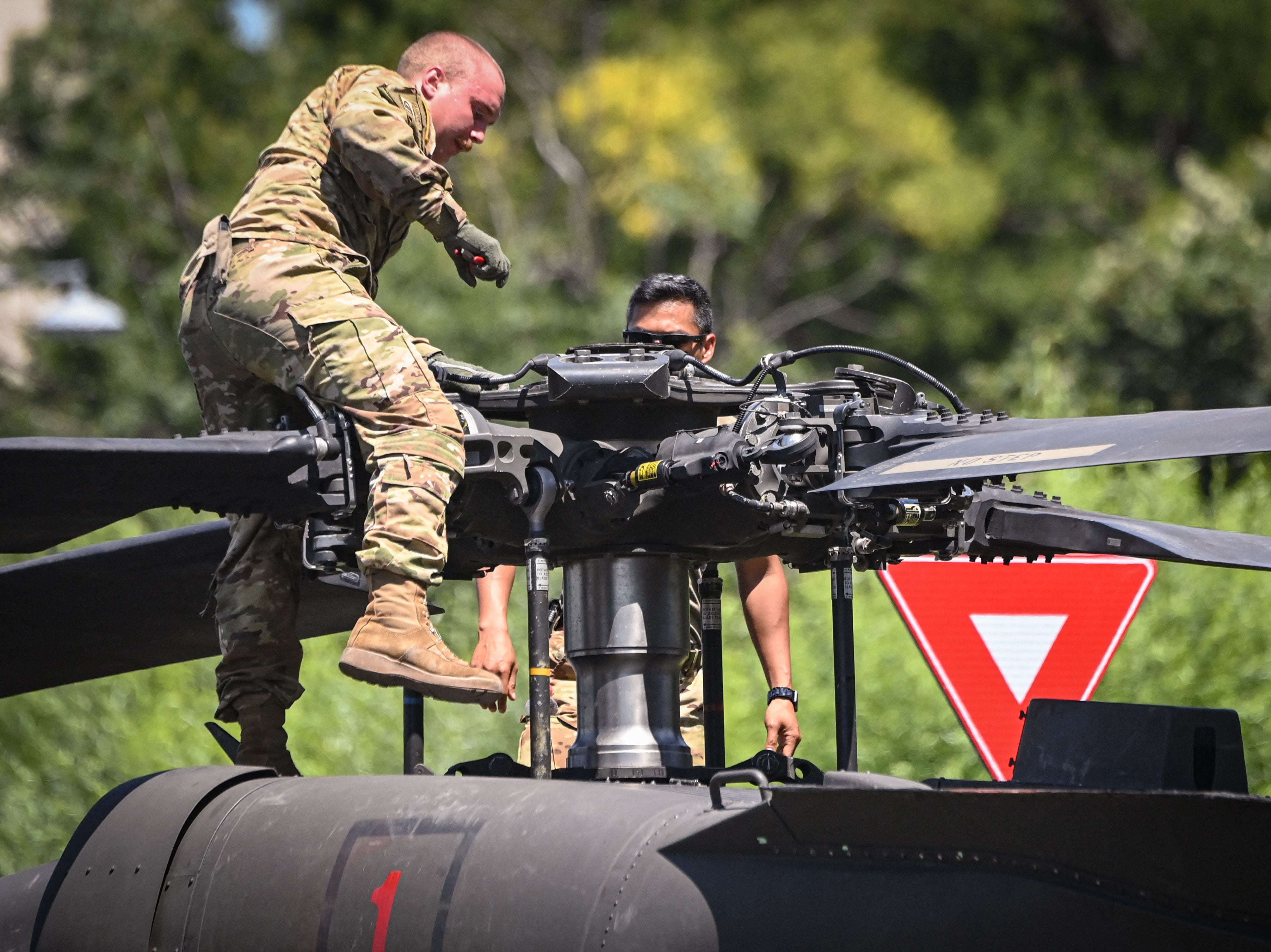 Military personnel inspect a Black Hawk helicopter at Charles de Gaulle square in Bucharest on July 15, 2021, after it forced landed, apparentlly due to loosing power during a mission flight over the city.