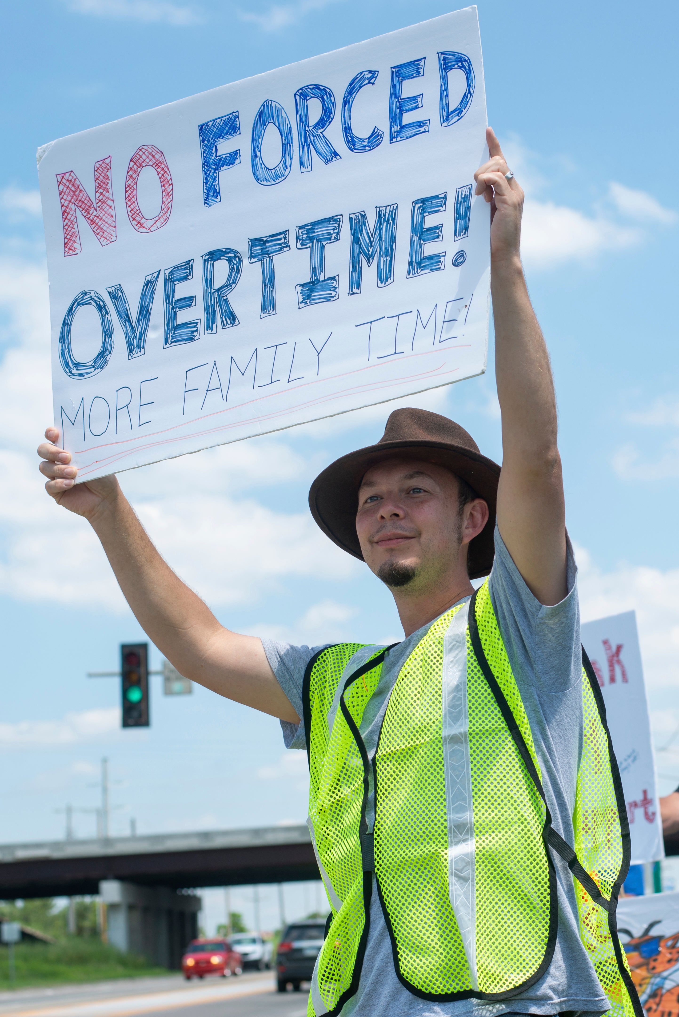 Monk Drapeaux-Stewart holds a sign reflecting compromising work-life balance during a strike against Frito-Lay outside of the plant in Topeka, Kansas Tuesday 13 July 13 2021.