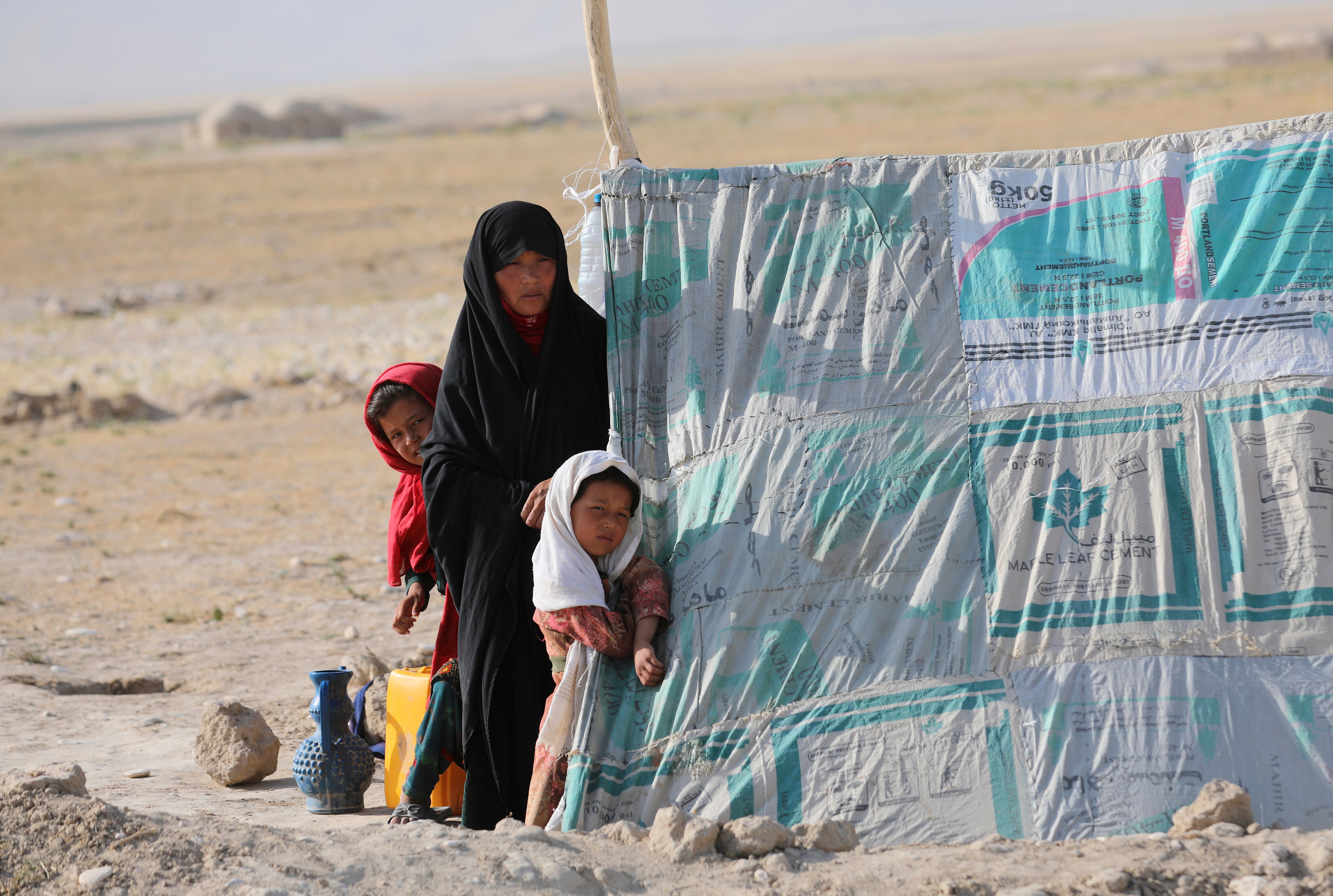 Afghan woman who is internally displaced with her daughters in city of Mazar-e-Sharif in northern Afghanistan in early July