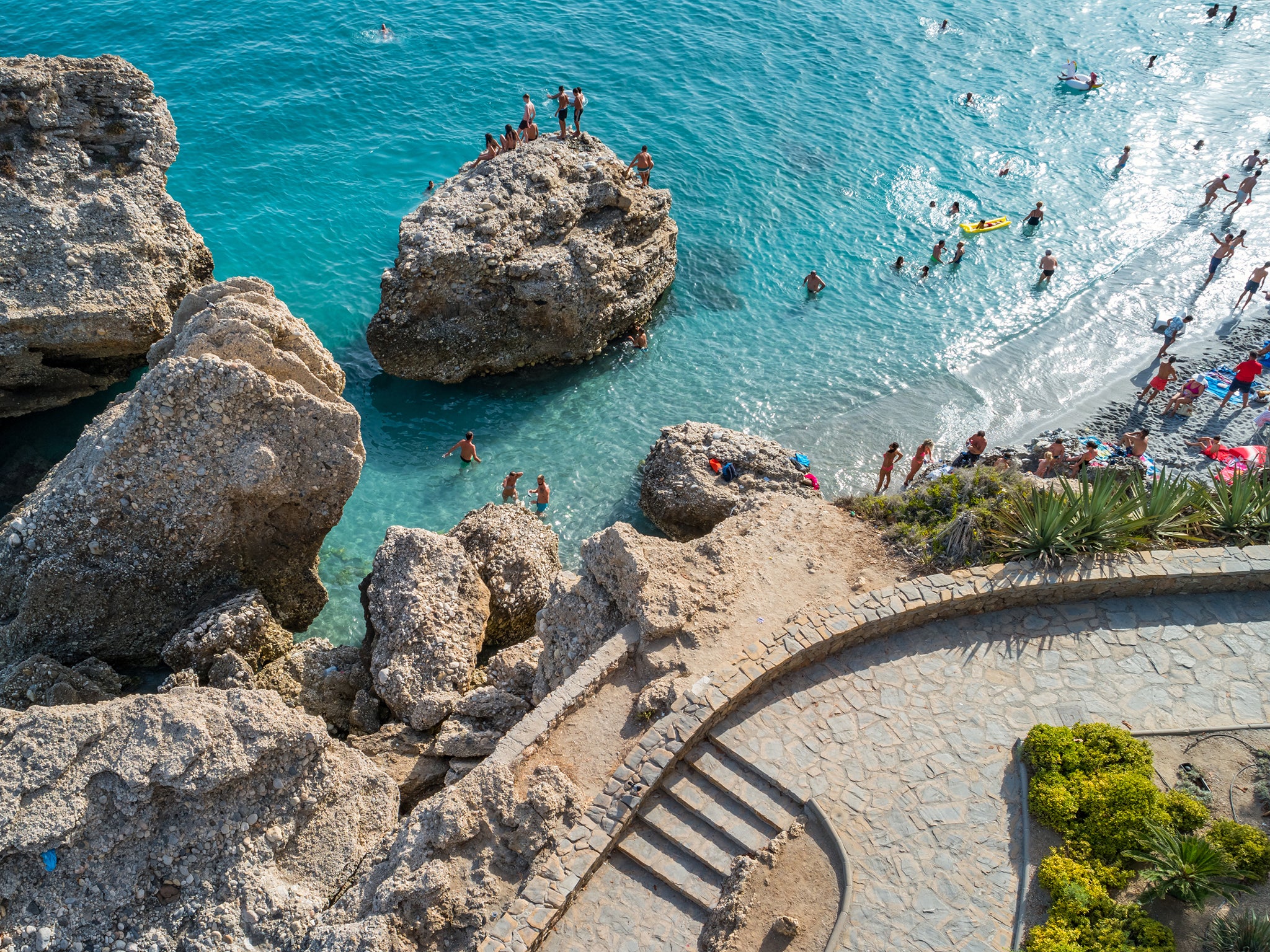 People enjoy a sunny day at the beach in Nerja, Costa del Sol, Andalusia, Spain