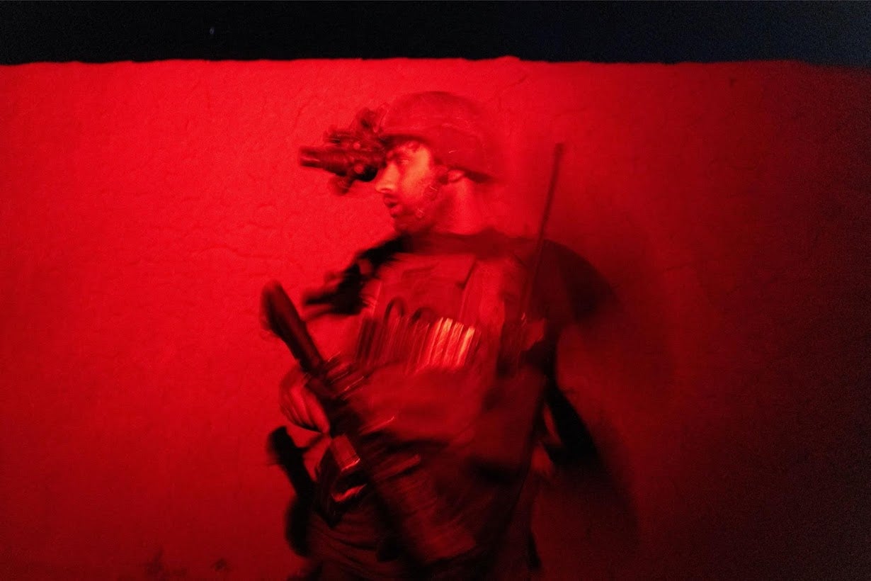 A member of the Afghan special forces keeps watch as others search a house during a combat mission against the Taliban in Kandahar province, Afghanistan, in 2021