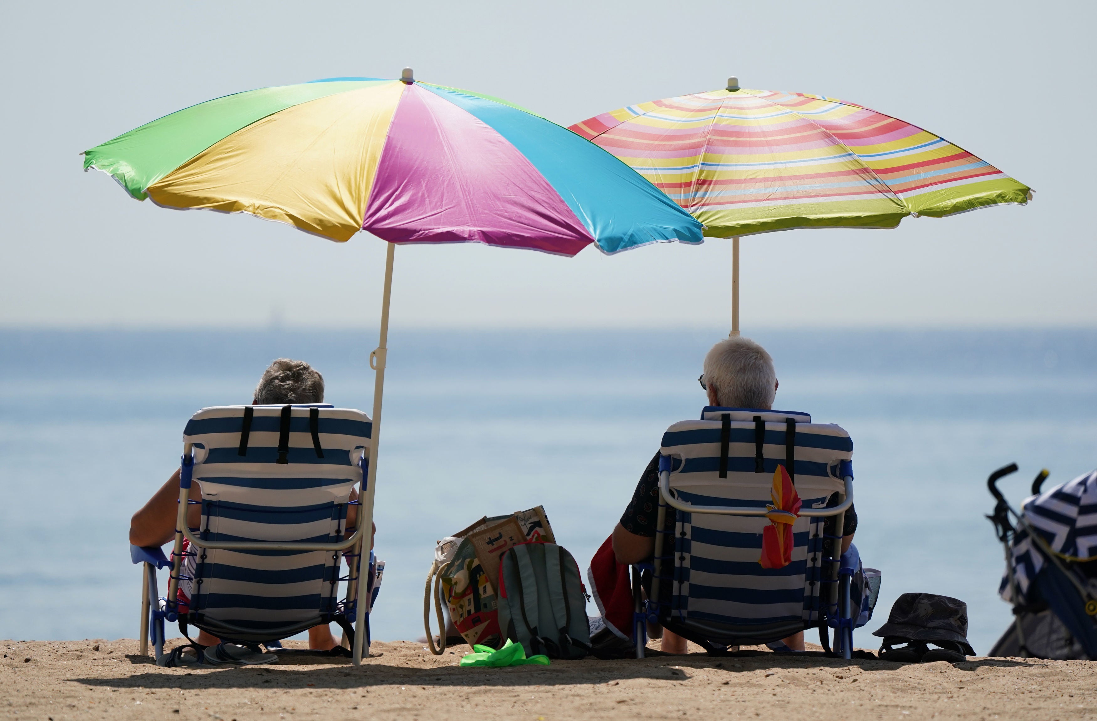 Beachgoers sit under umbrellas in Bournemouth