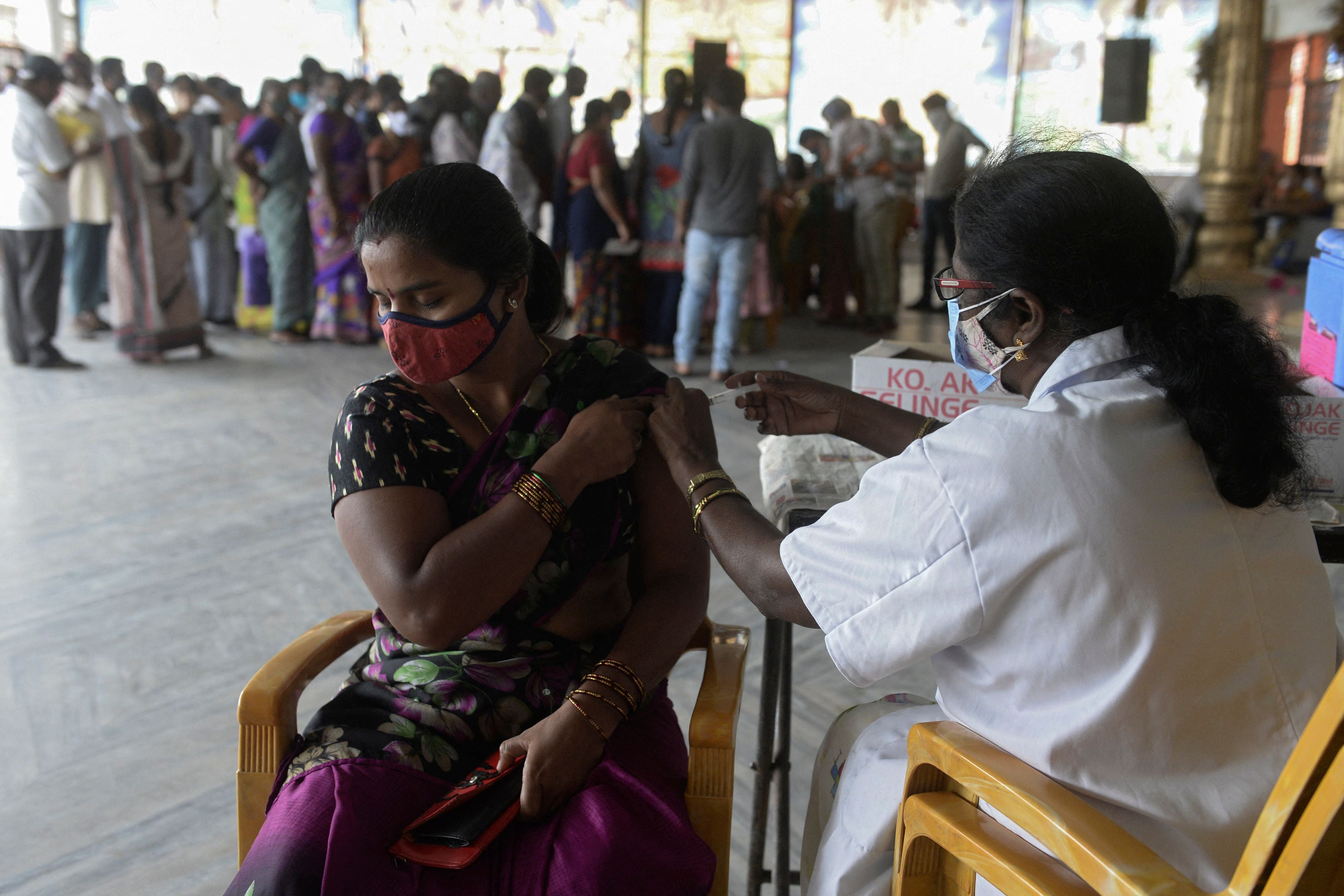 A health worker inoculates a woman with a dose of a Covid-19 vaccine