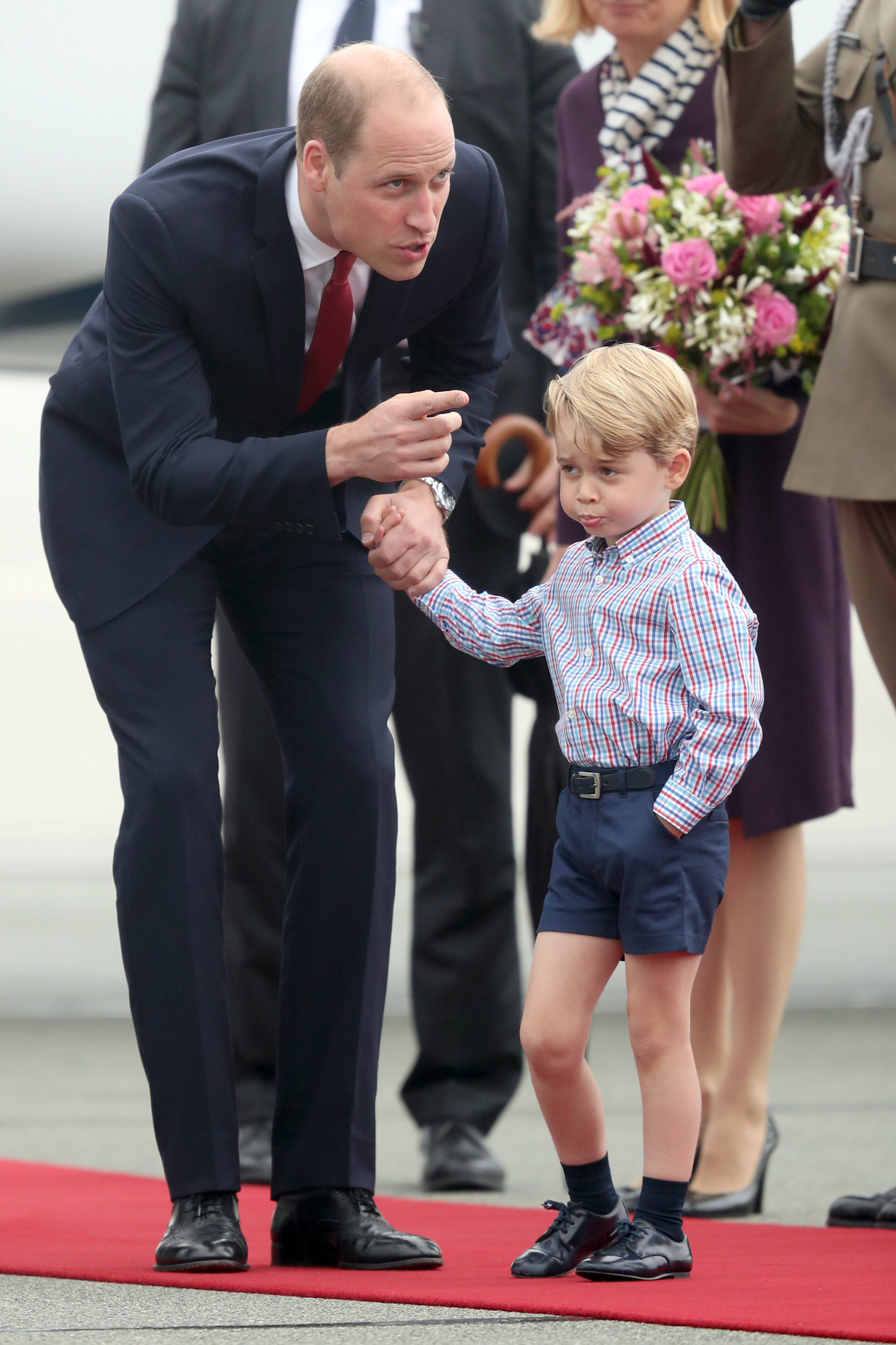 Prince George holding the hand of his father, the Duke of Cambridge, at Warsaw’s Chopin Airport (Jane Barlow/PA)