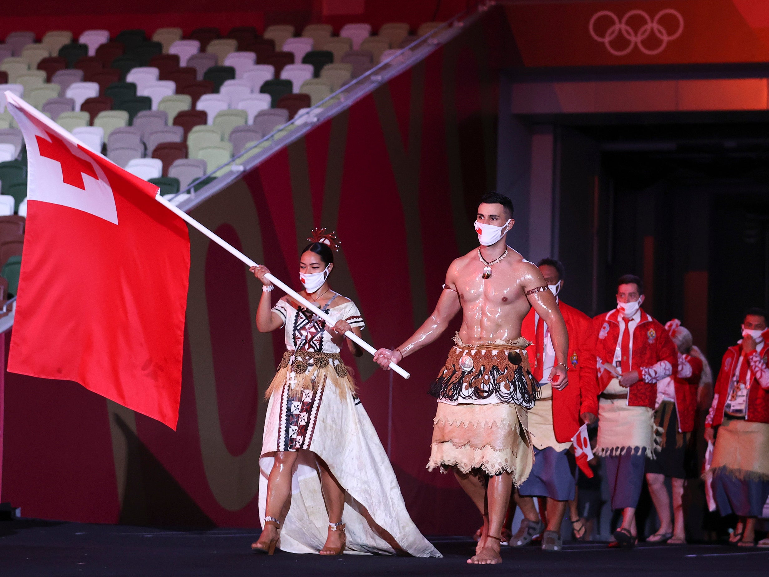 Flag bearers Malia Paseka and Pita Taufatofua of Team Tonga lead their team out during the Opening Ceremony of the Tokyo 2020 Olympic Games