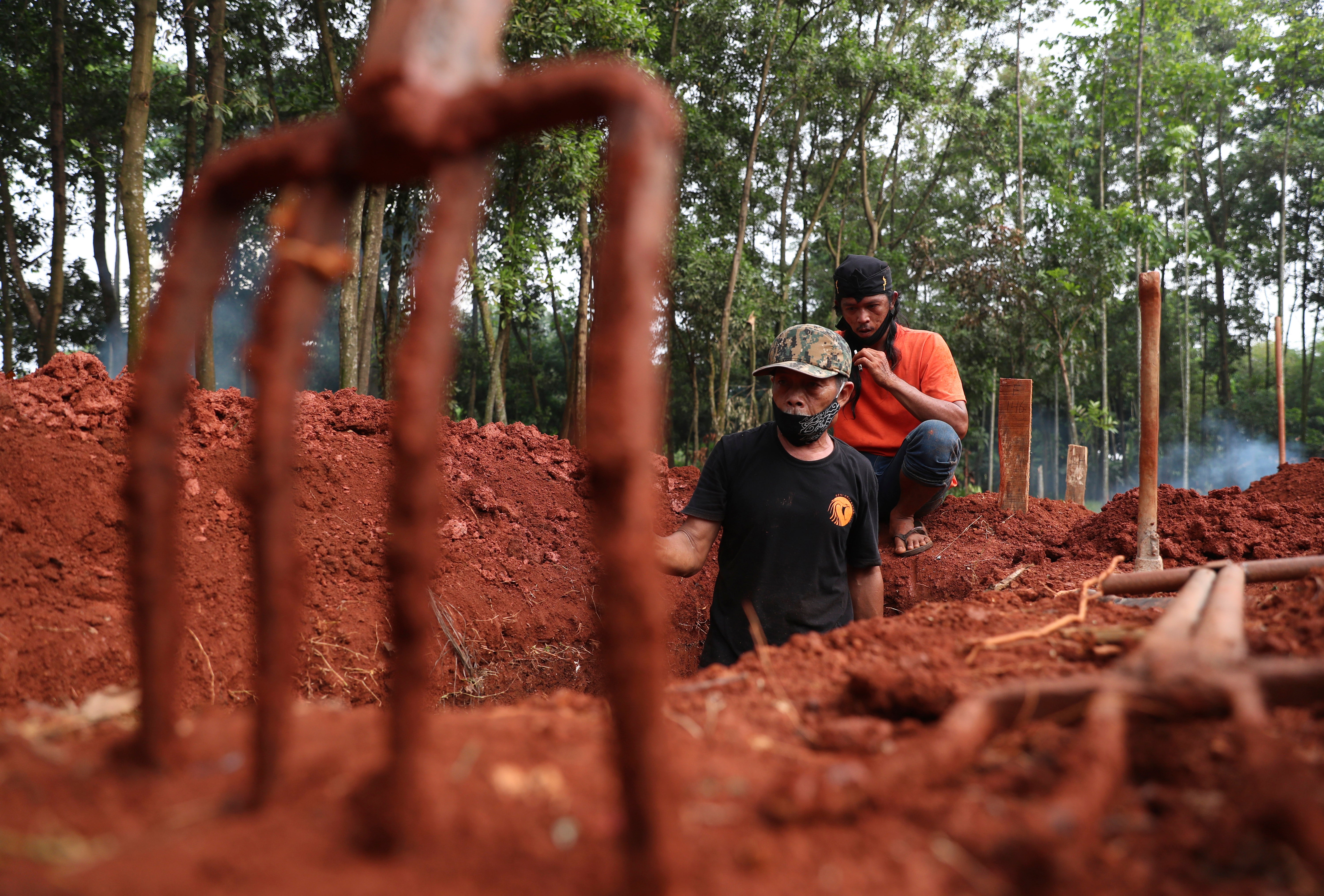 Relatives prepare a grave for a covid-19 victim at Cipenjo cemetery in Bogor, West Java, Indonesia.