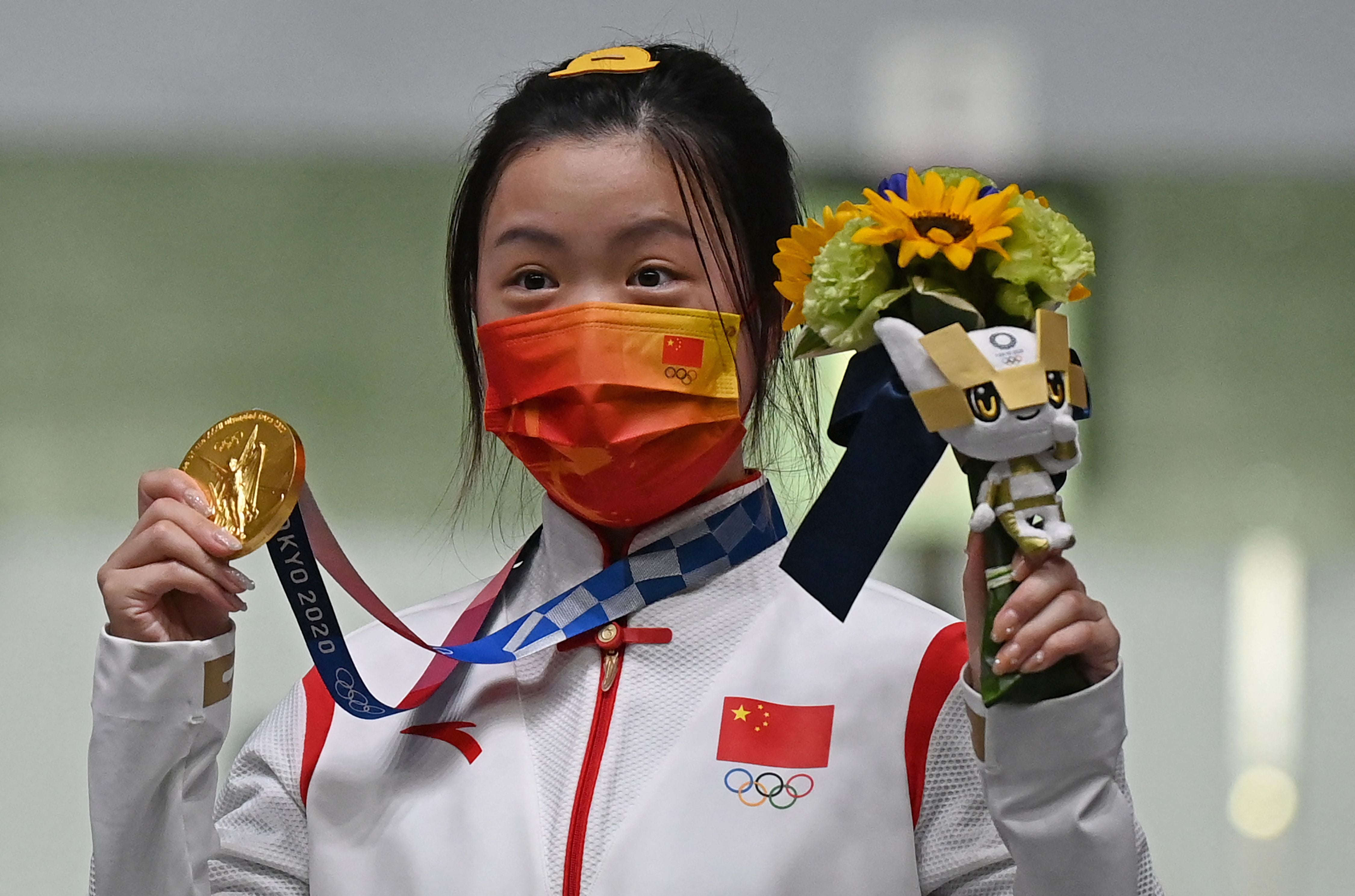 China’s Yang Qian celebrates on the podium after winning the women’s 10-metre air rifle final on Saturday. It was the first gold of the Tokyo Games