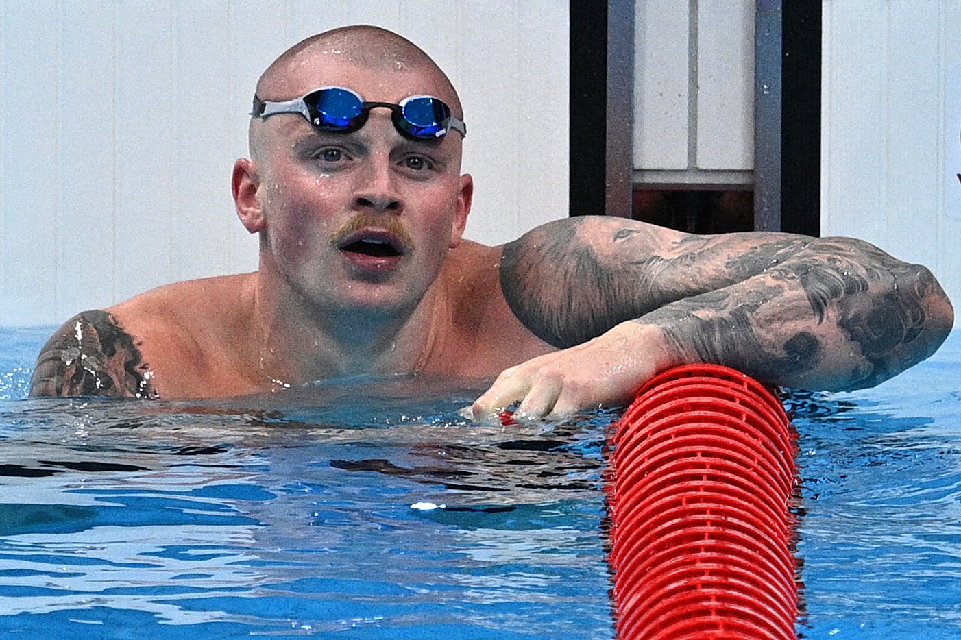 Adam Peaty checks the big screen after winning his heat