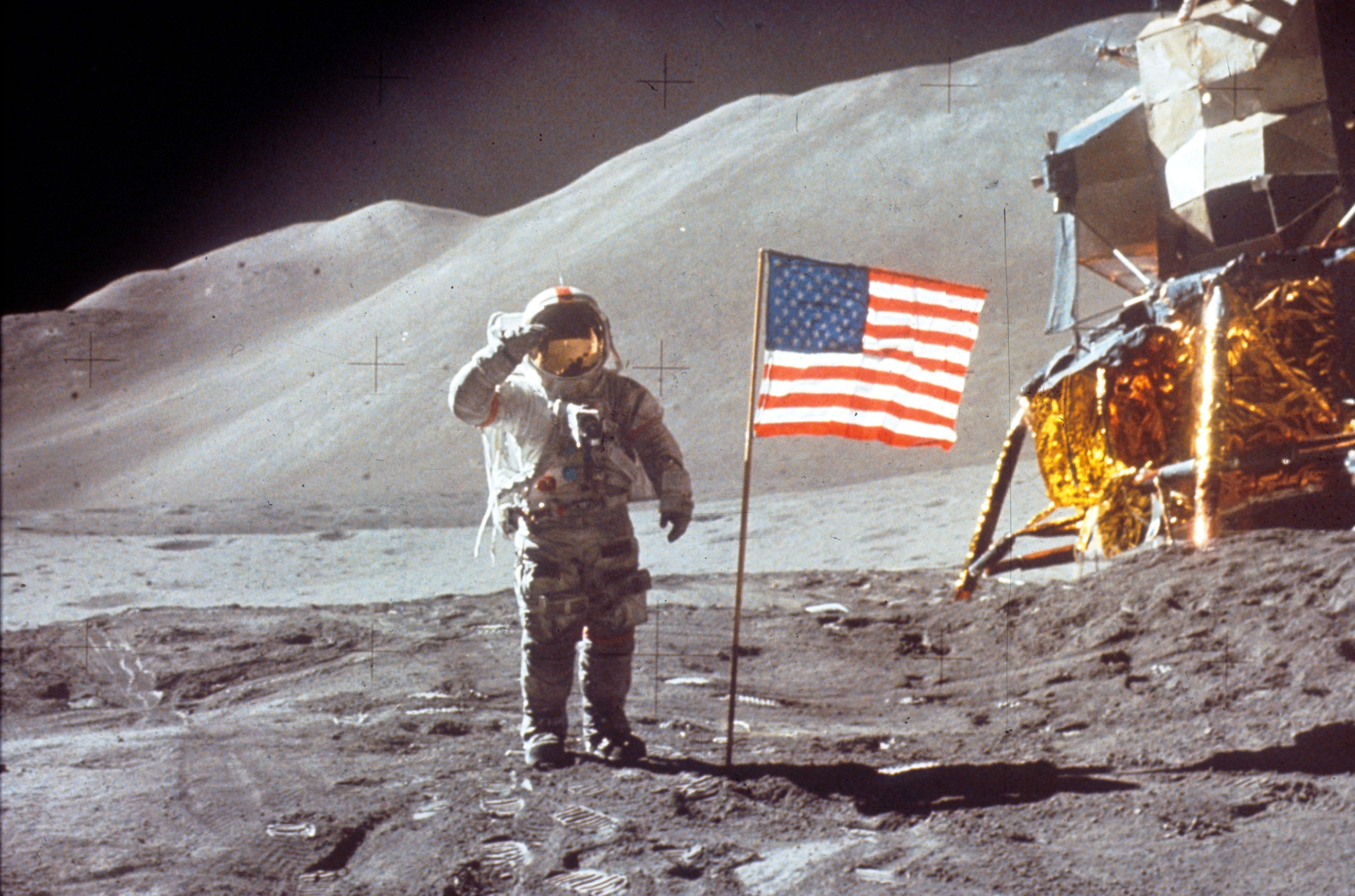 Scott salutes the camera next to the US flag after landing on the moon on 30 July 1971