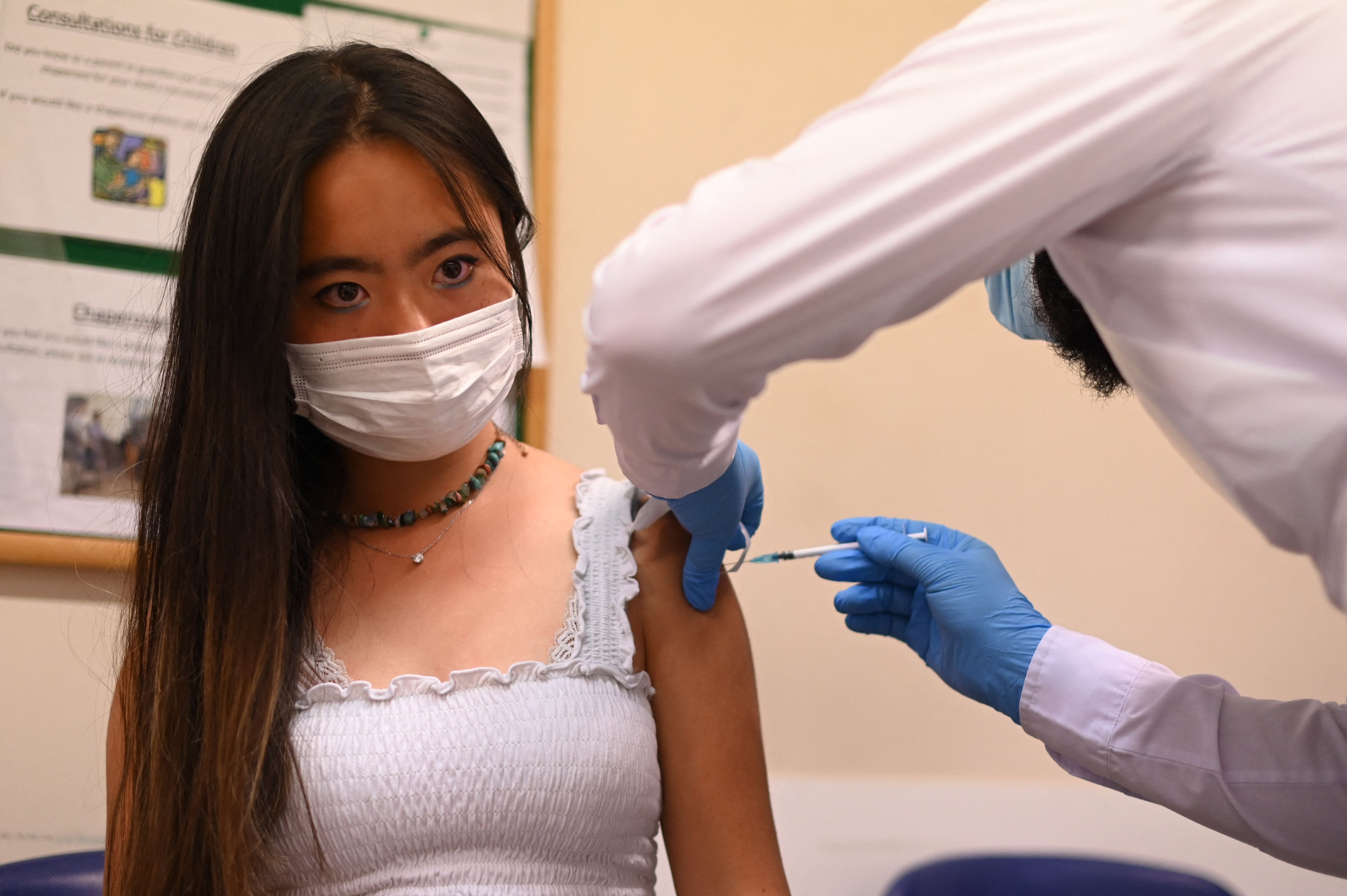 A student is given a dose of the Pfizer/BioNTech vaccine at a health centre in London