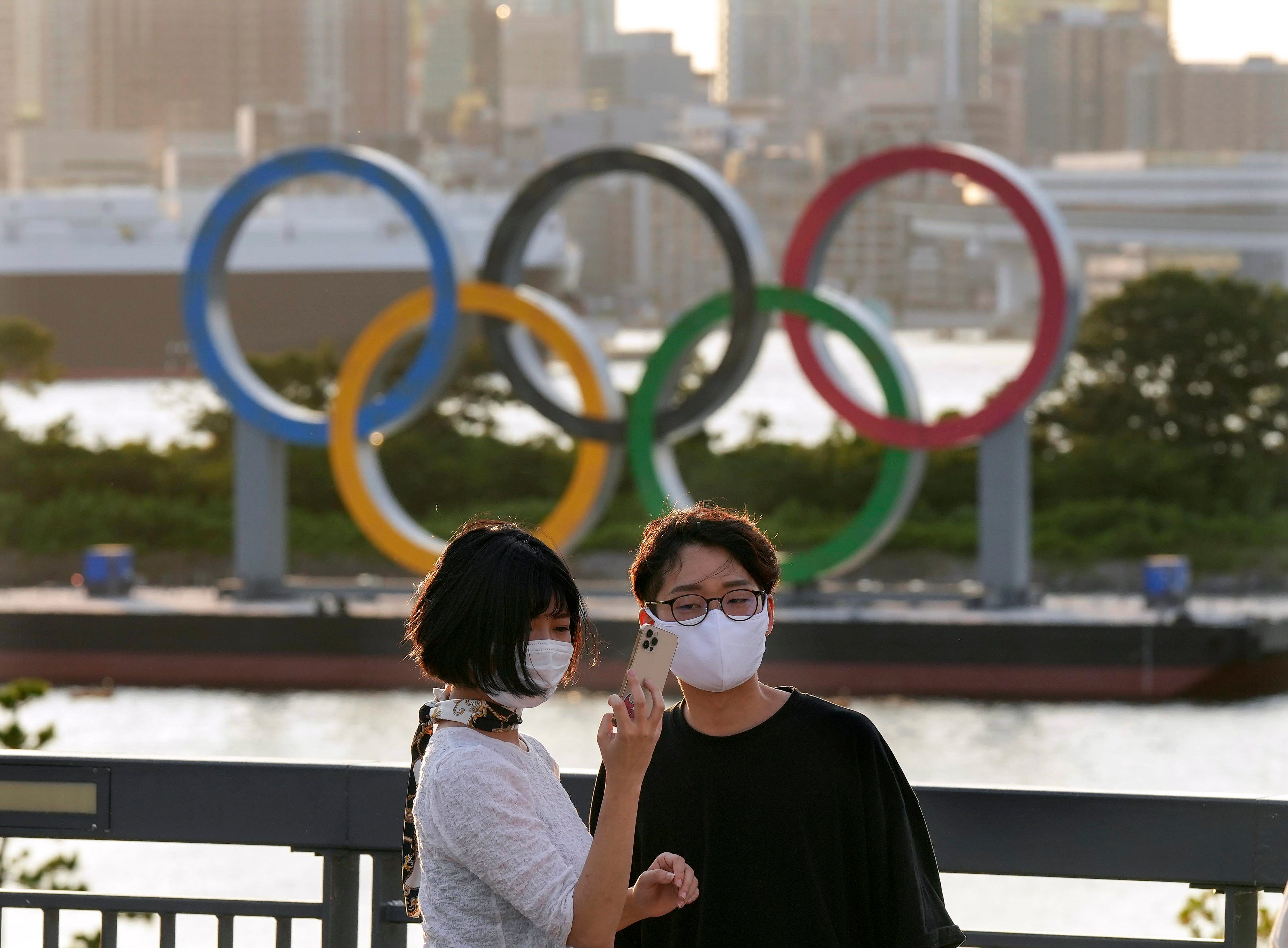 <p>A couple takes a commemorating selfie with the Olympic Ring Monument at Odaiba in Tokyo</p>