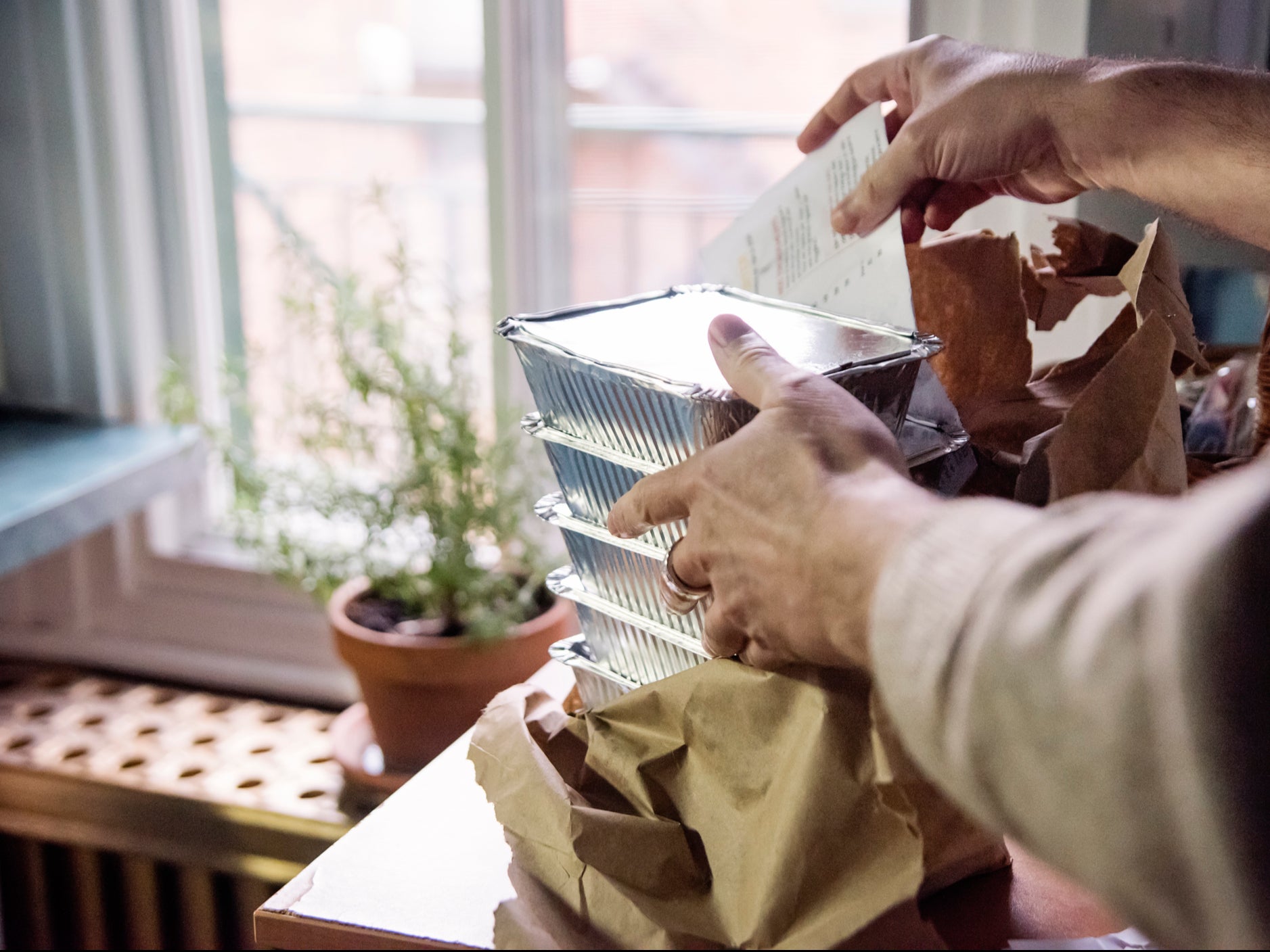 A person opens a bag of takeaway food