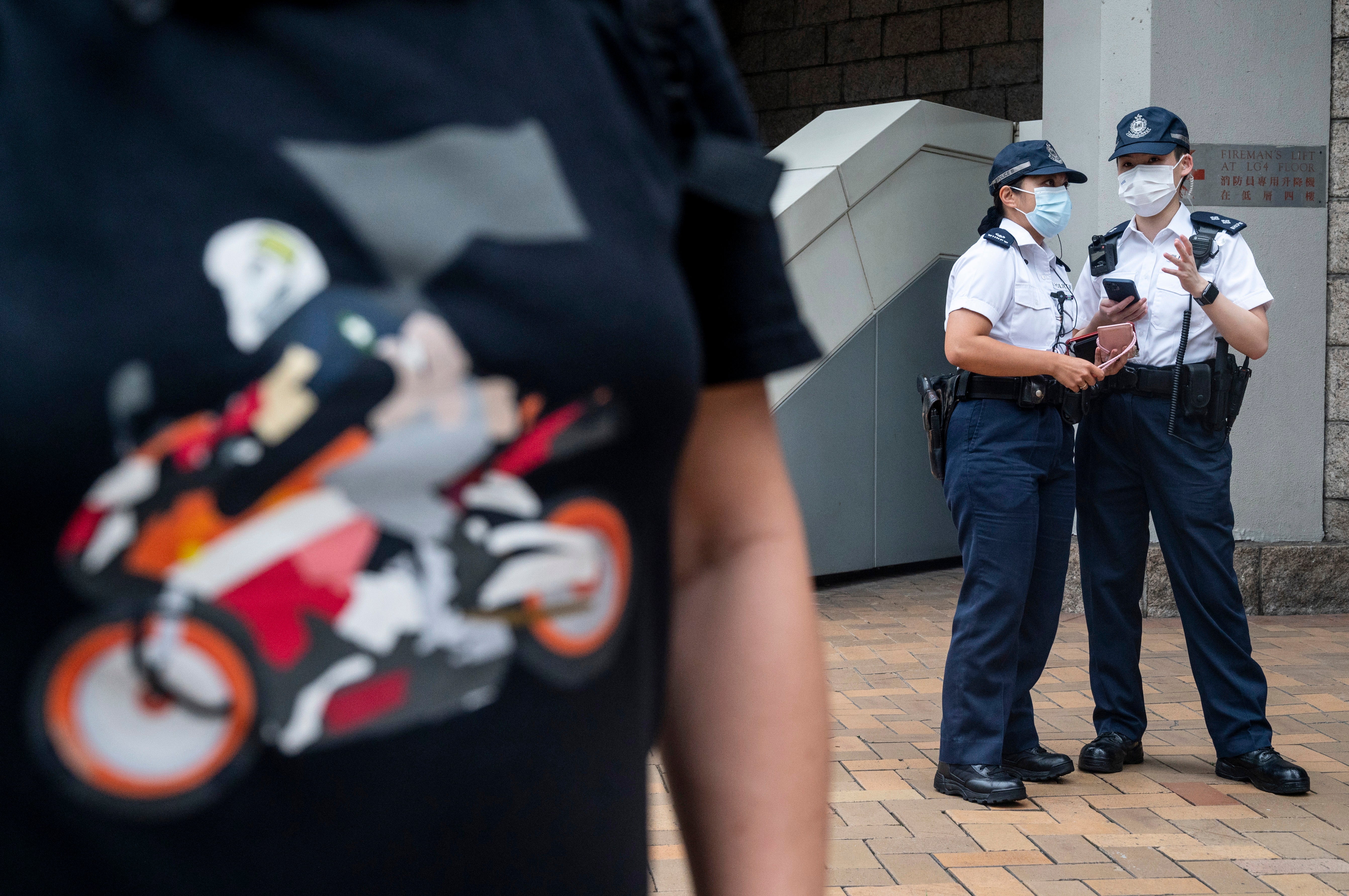 A person (L), wearing a shirt in support of convicted Tong Ying-kit, stands outside the High Court in Hong Kong, China, 27 July 2021. Tong Ying-kit, 24, is the first defendant to be found guilty for secession and terrorism under the Beijing-imposed national security law