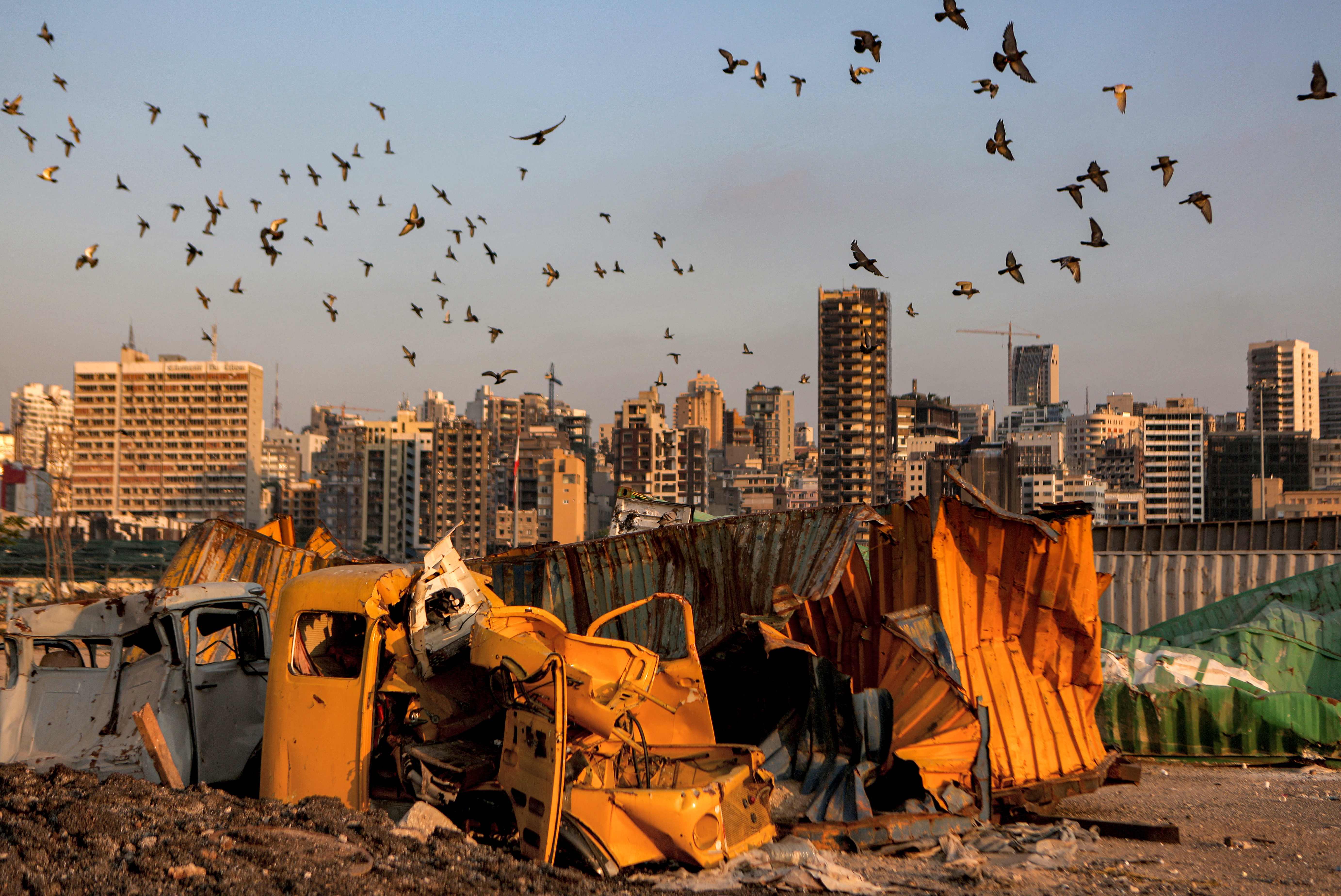 Pigeons fly over destroyed containers at the port of Lebanon's capital Beirut