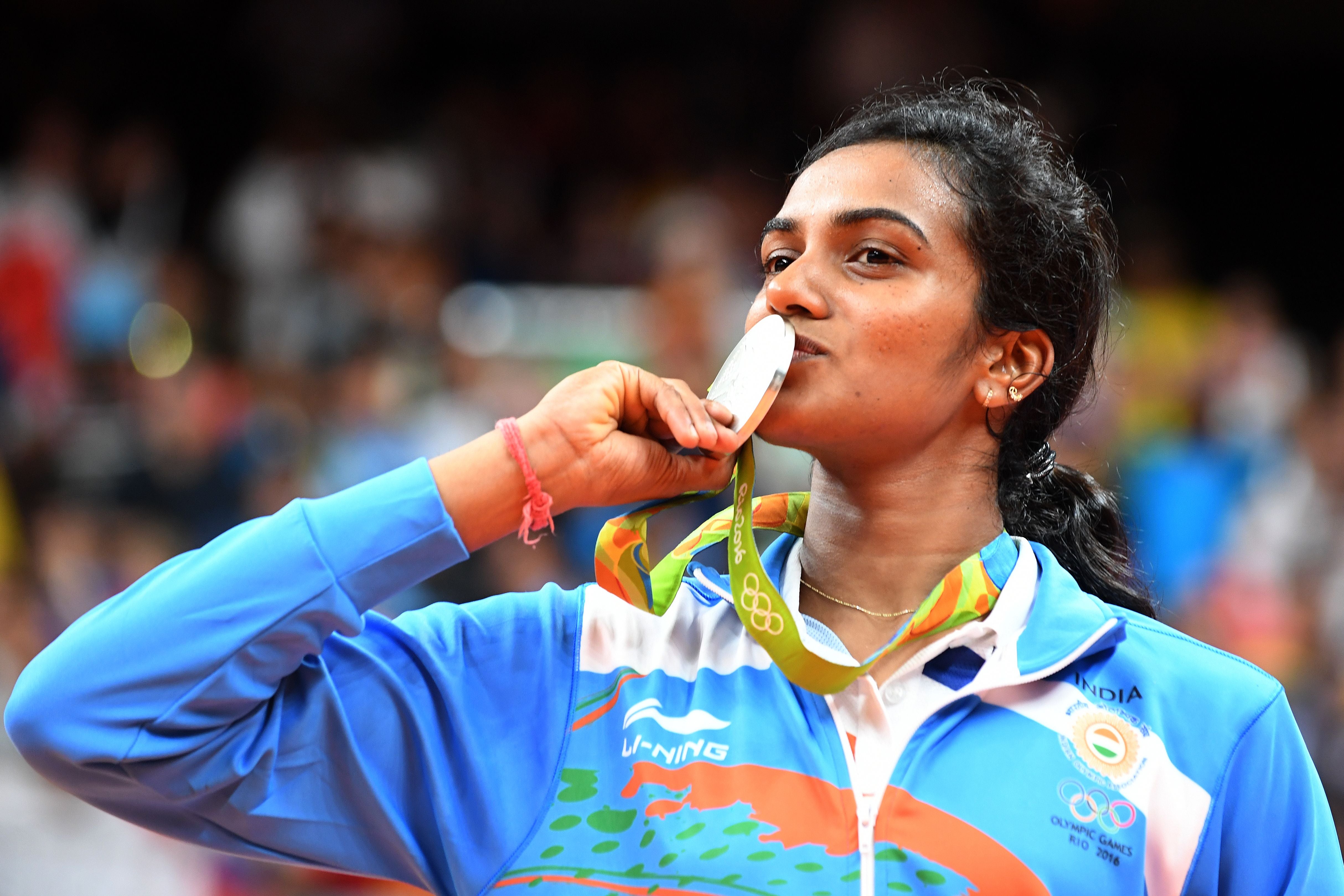 Silver medalist India's Pusarla V Sindhu celebrates on the podium following the women's singles Gold Medal badminton match at the Riocentro stadium in Rio de Janeiro on 19 August 2016, for the Rio 2016 Olympic Games