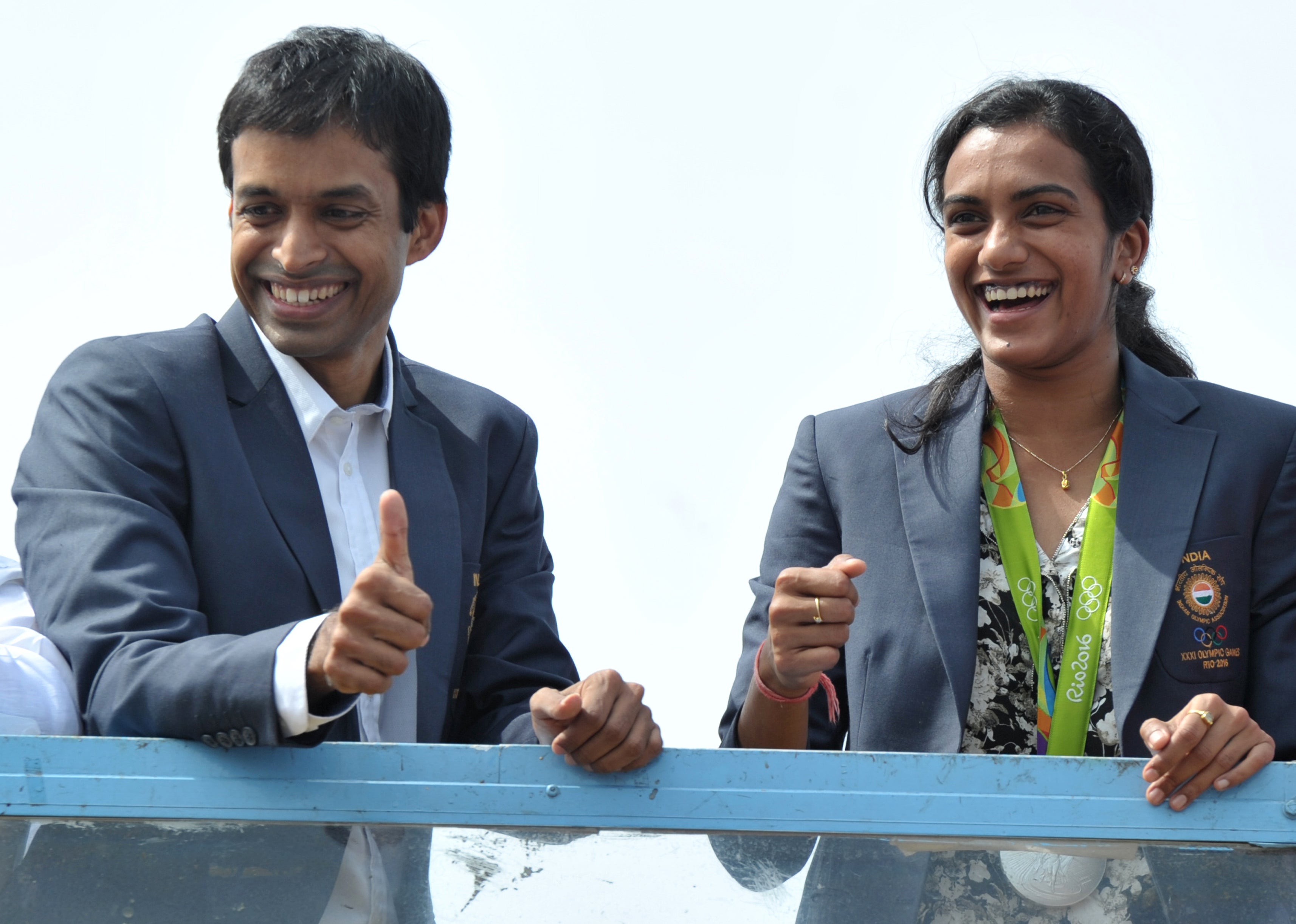 Indian badminton player and Olympic silver medalist PV Sindhu (R) and her coach P Gopichand take part in a parade after arriving home from the Rio Olympics in Hyderabad on 22 August 2016