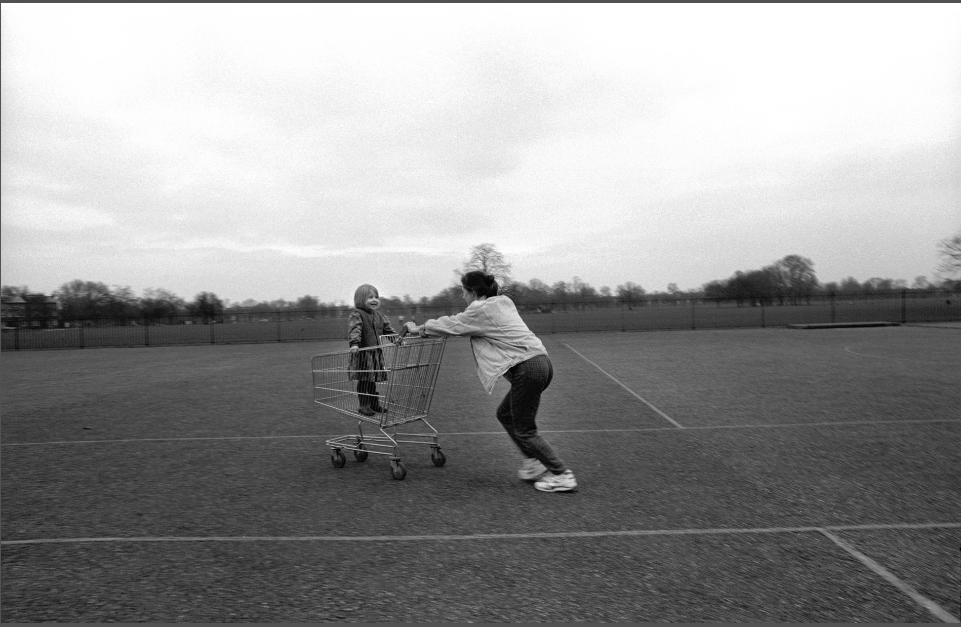 A grandmother pushes her grandchild through a parking lot in Clapham Common, 1996