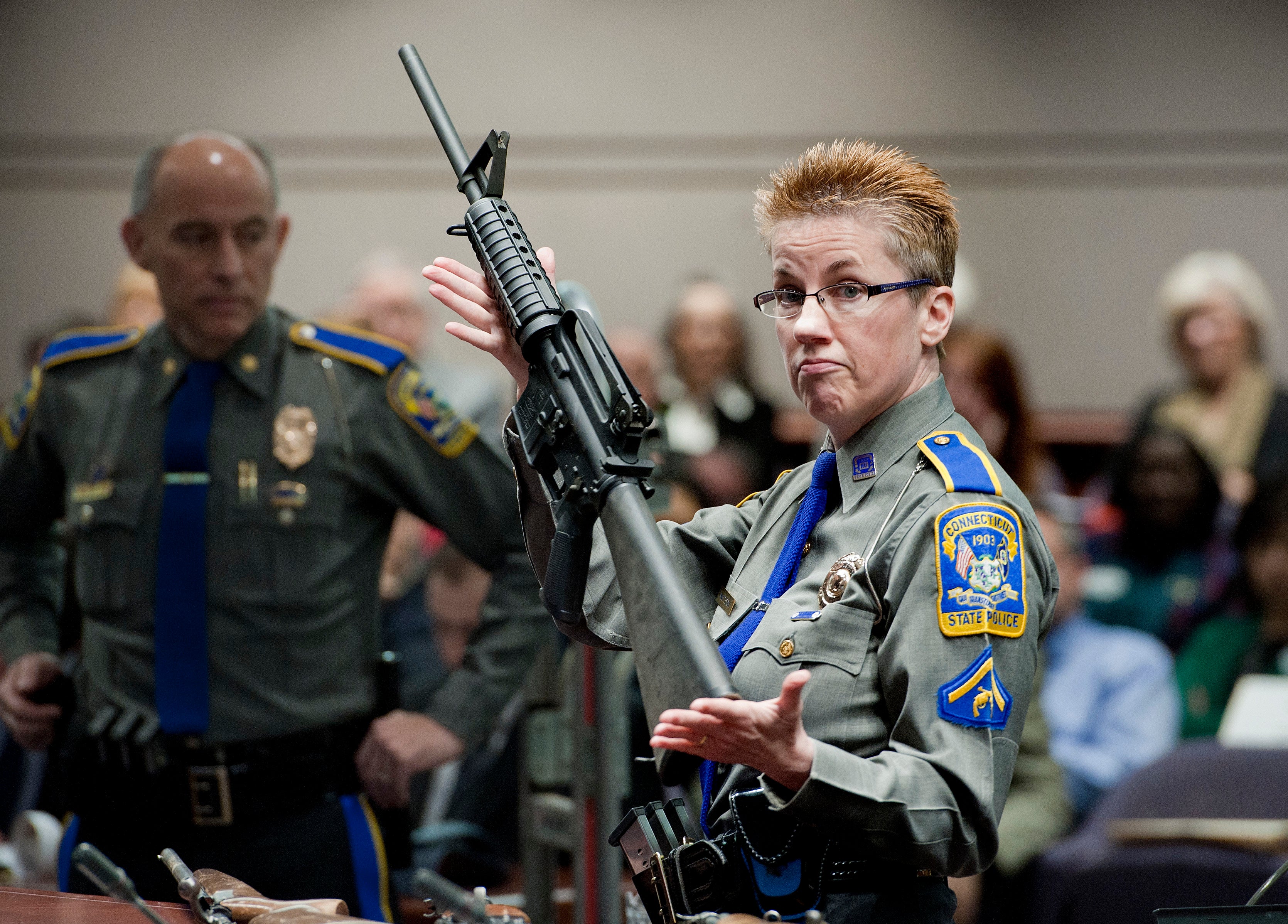 In this 28 January 2013 file photo, firearms training unit Detective Barbara J. Mattson, of the Connecticut State Police, holds up a Bushmaster AR-15 rifle, the same make and model of gun used by Adam Lanza in the Sandy Hook School shooting, for a demonstration during a hearing of a legislative subcommittee reviewing gun laws, at the Legislative Office Building in Hartford, Conn.