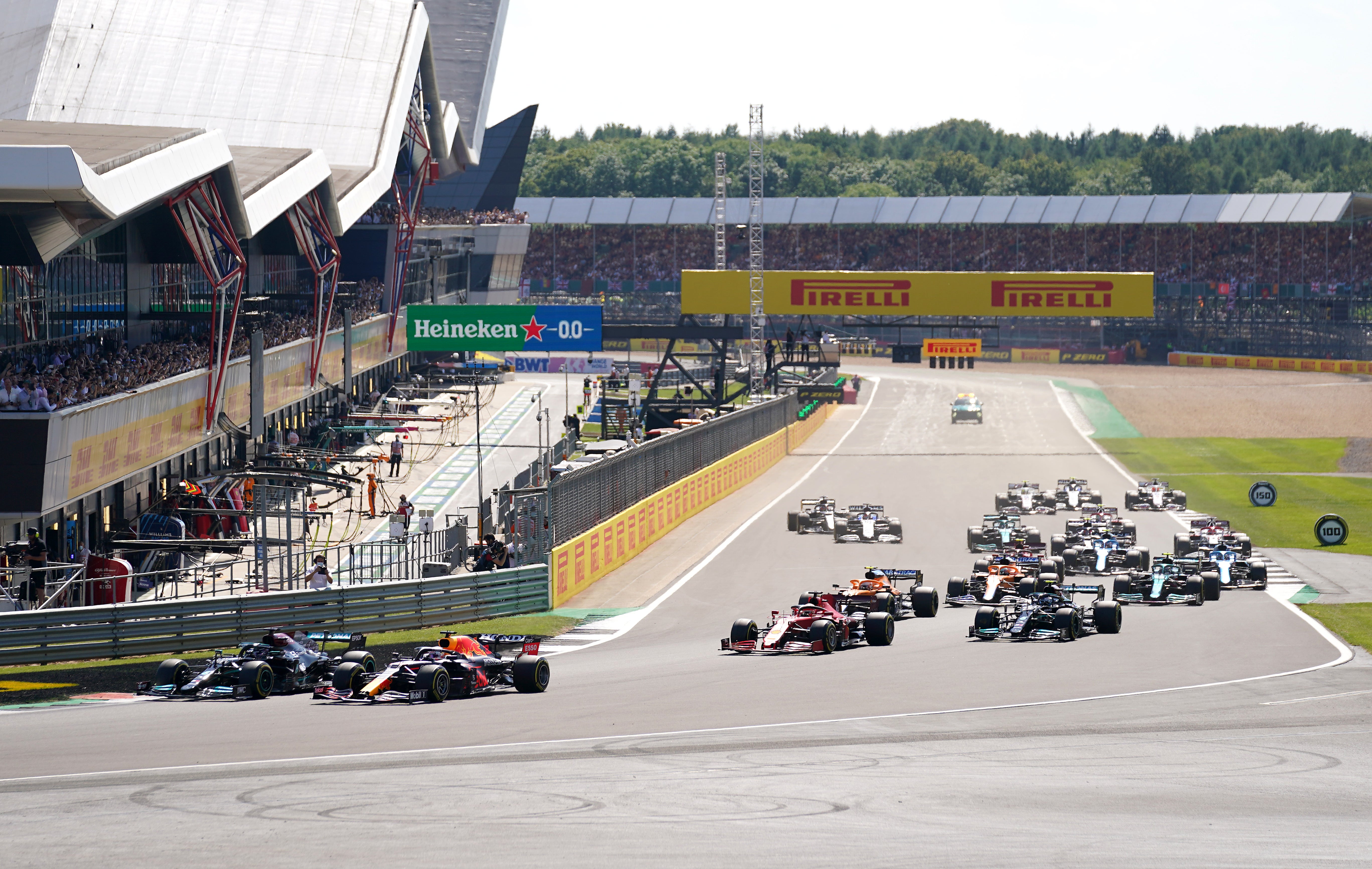 Mercedes’ Lewis Hamilton and Red Bull Racing’s Max Verstappen lead the race at the start of the race during the British Grand Prix at Silverstone, Towcester. Picture Date: Sunday July 18, 2021.