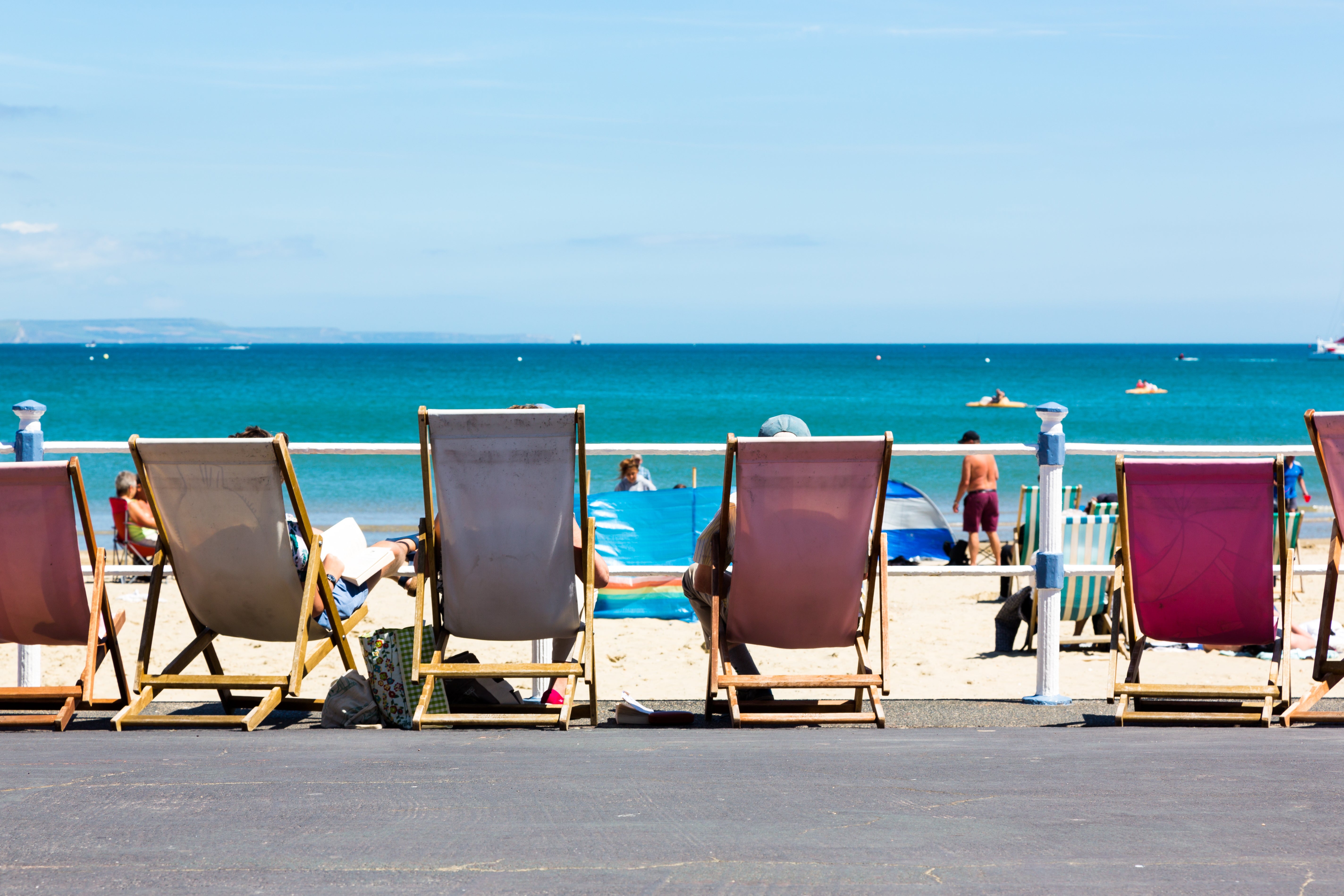 Deck chairs on Weymouth’s long promenade where skaters, mobility scooters, strollers and cyclists trundle