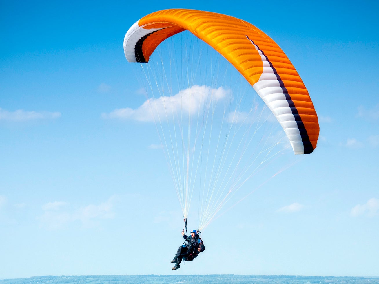 A hang glider takes off from the top of the White Horse