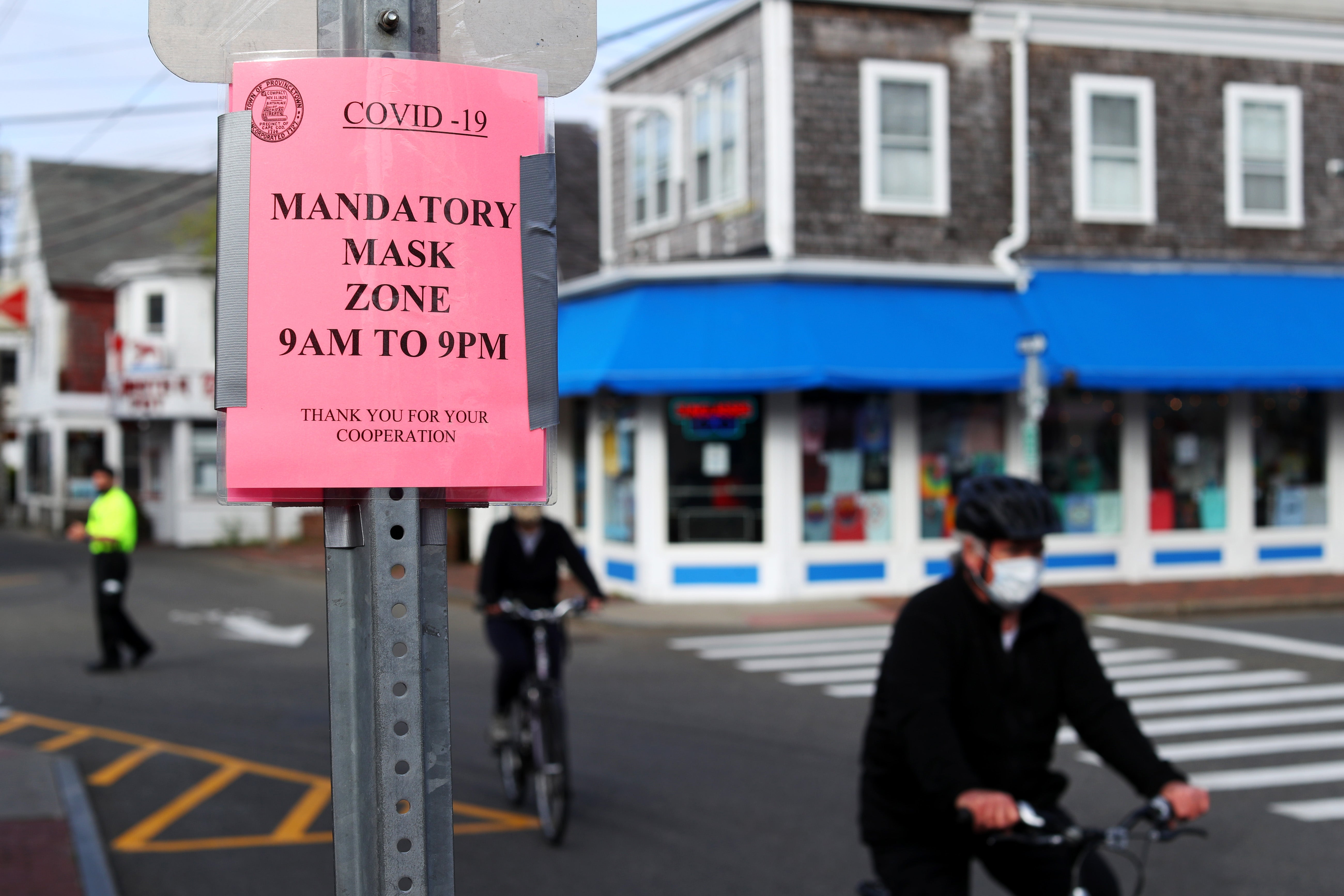 People bike down Commercial Street on May 25, 2020 in Provincetown, Massachusetts