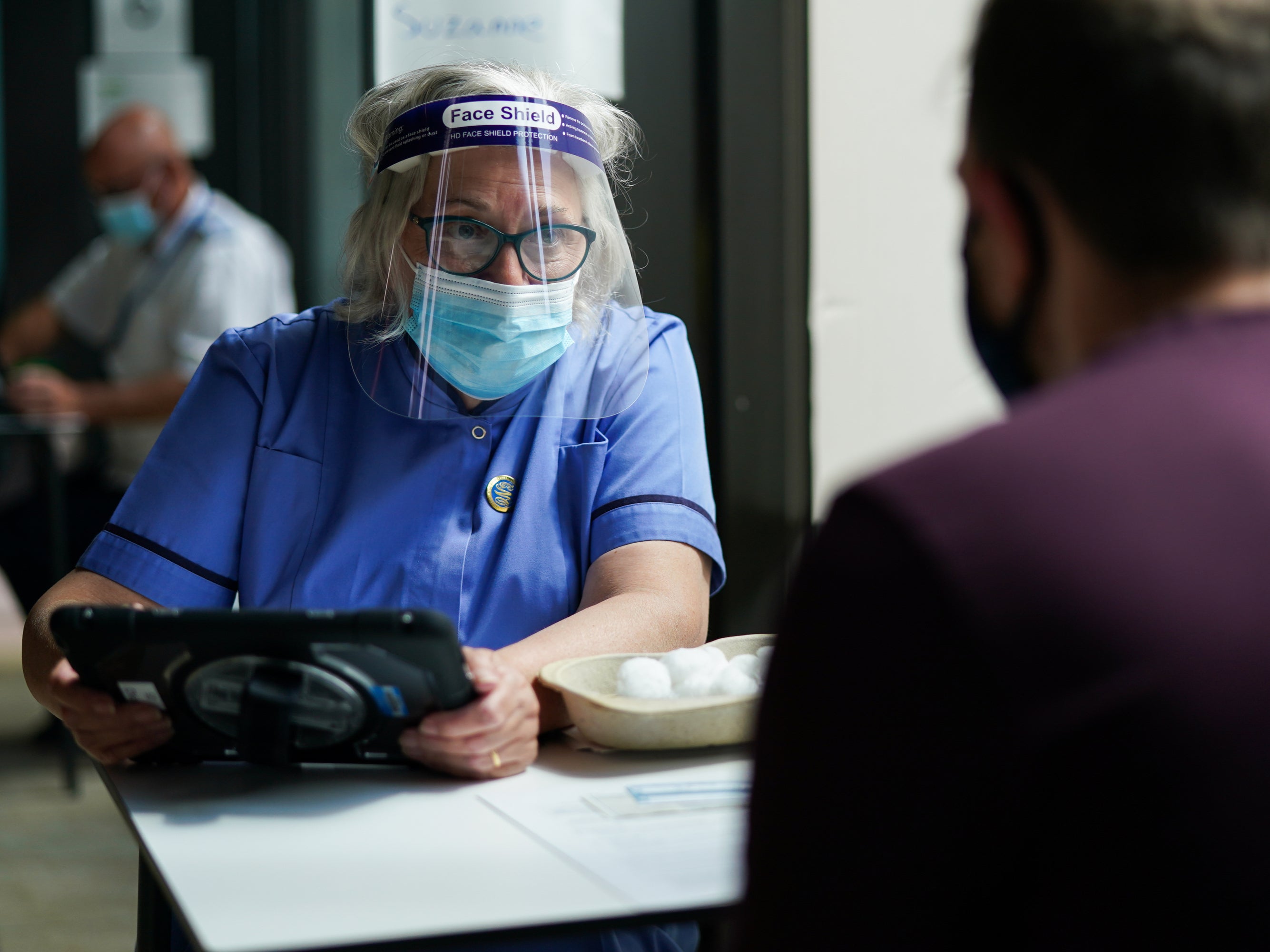 Suzanne Meadows, who administered the first ever Covid vaccine in the northeast region, briefs a patient before they receive jab