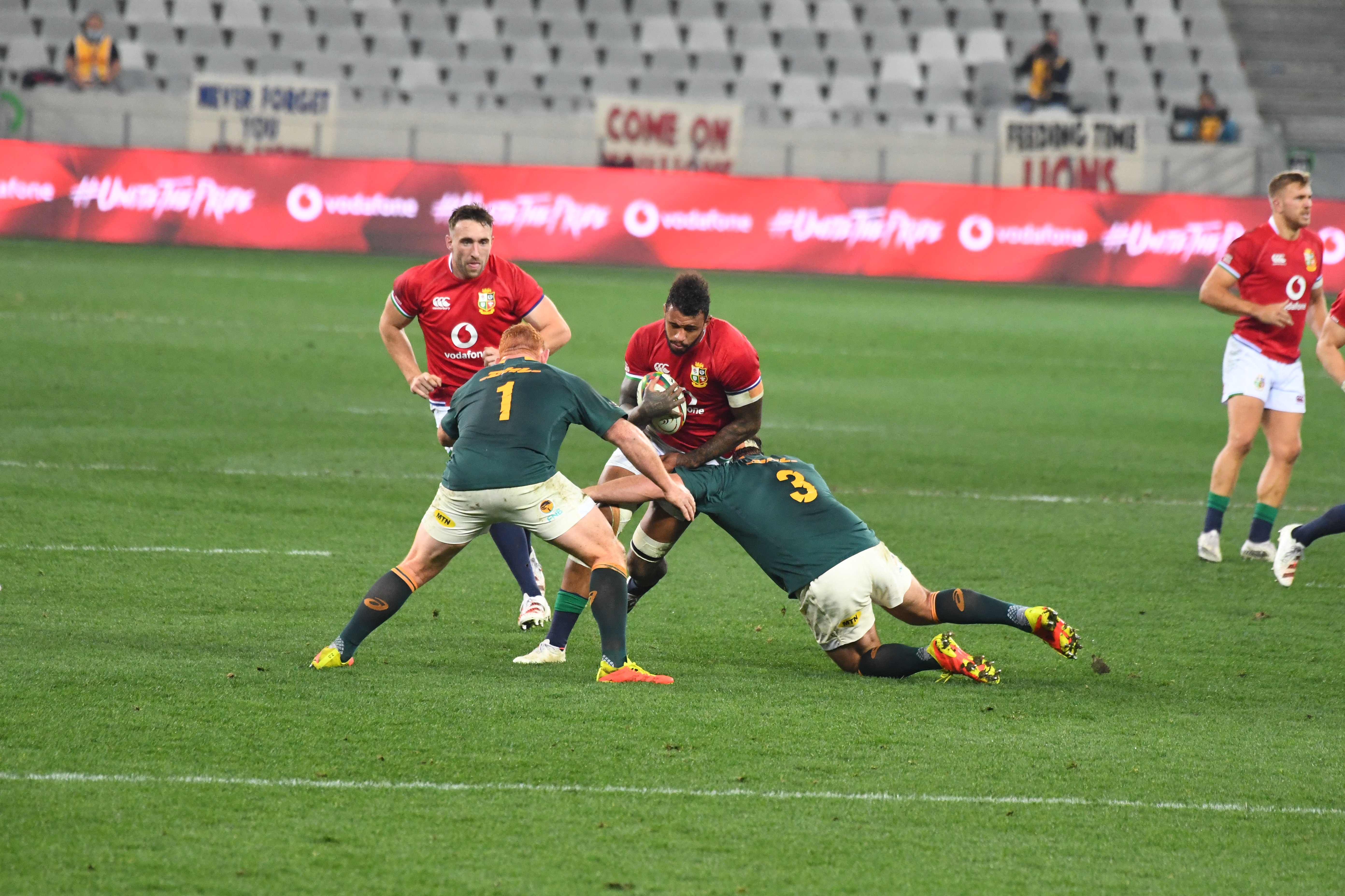 British and Irish Lions' flanker Courtney Lawes is tackled by South Africa's prop Steven Kitshoffand South Africa's prop Frans Malherbe