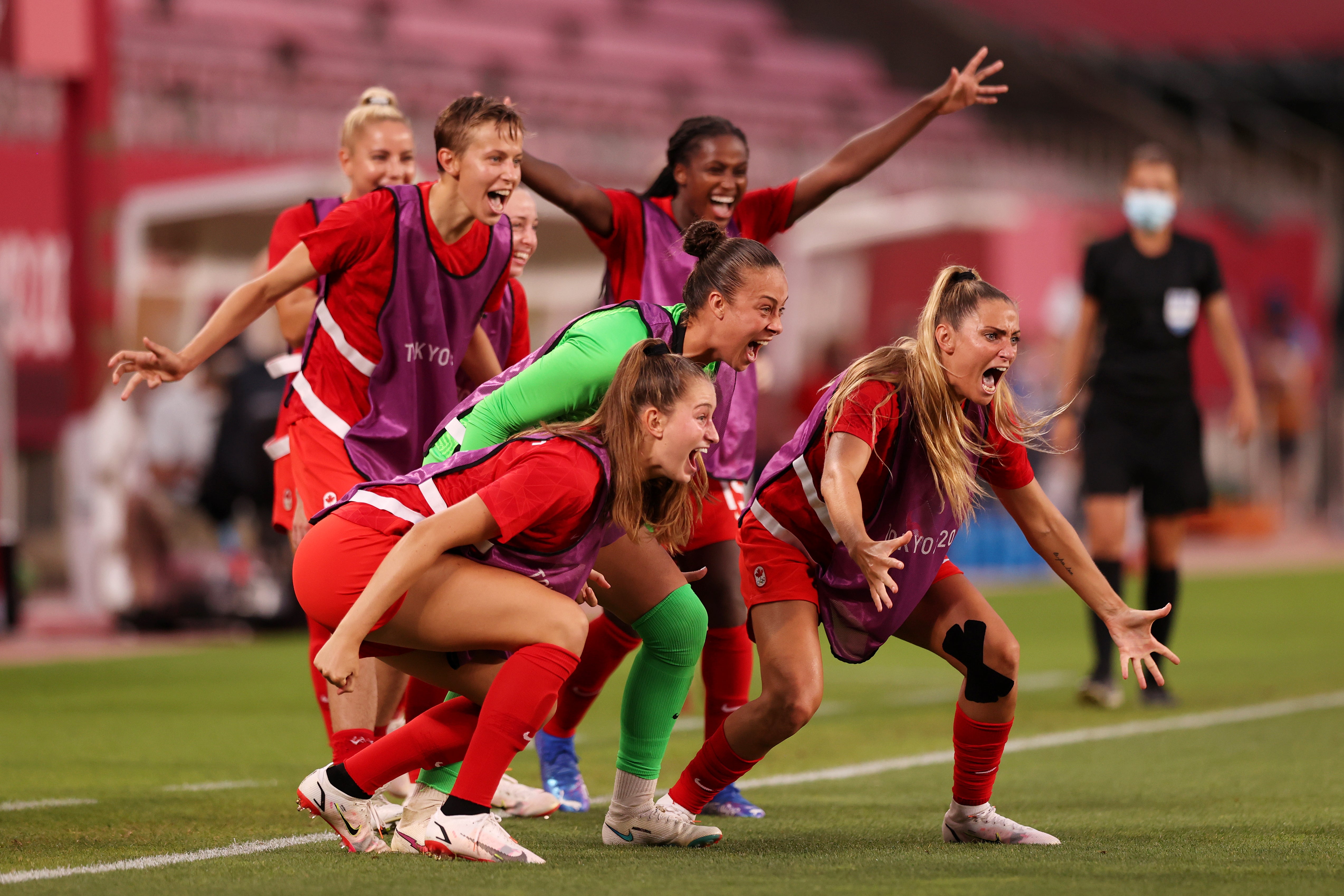 Players of Team Canada celebrate their side's first goal scored by Jessie Fleming