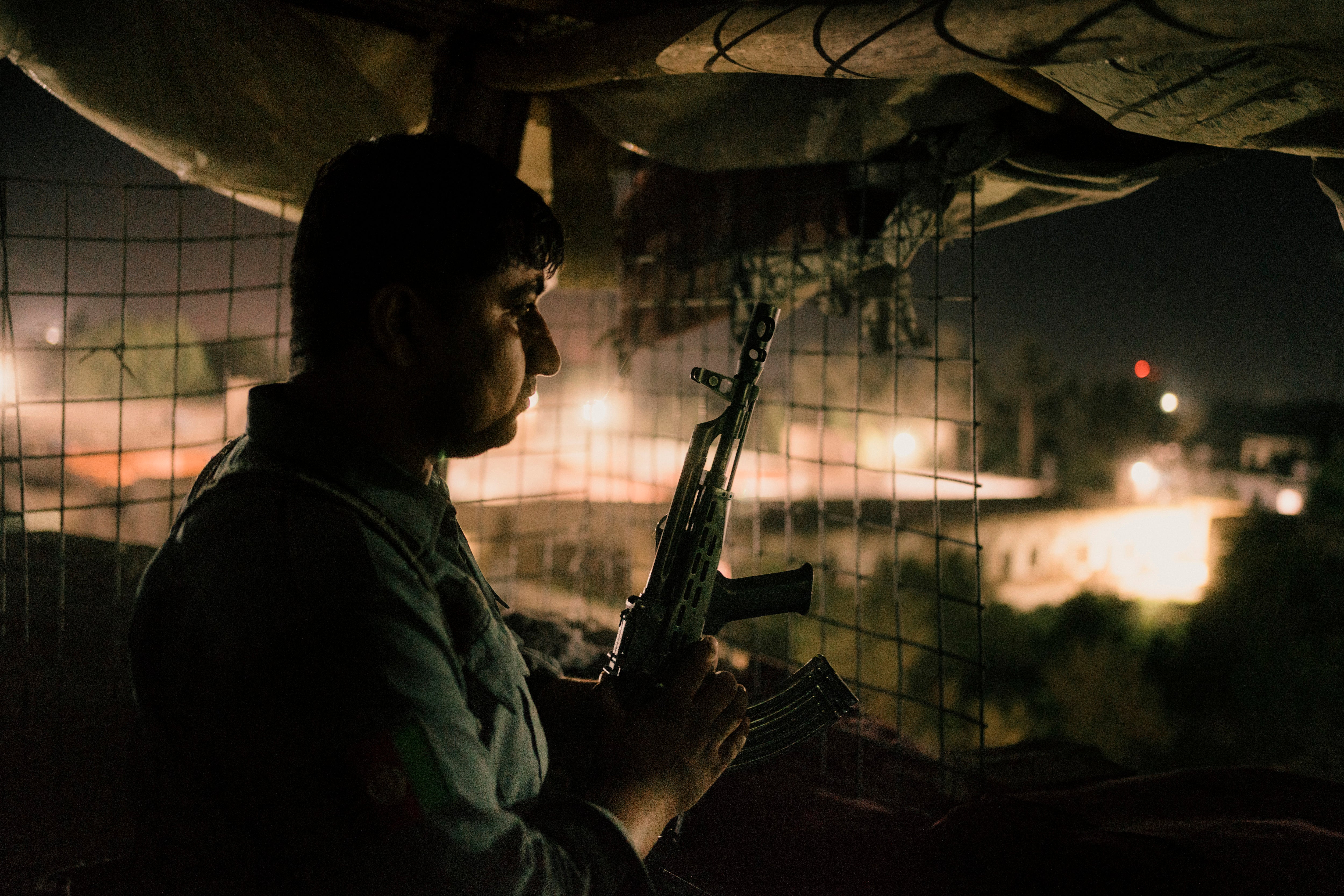 A policeman stands on guard duty in a tower along the security perimeter of the Kunduz prison