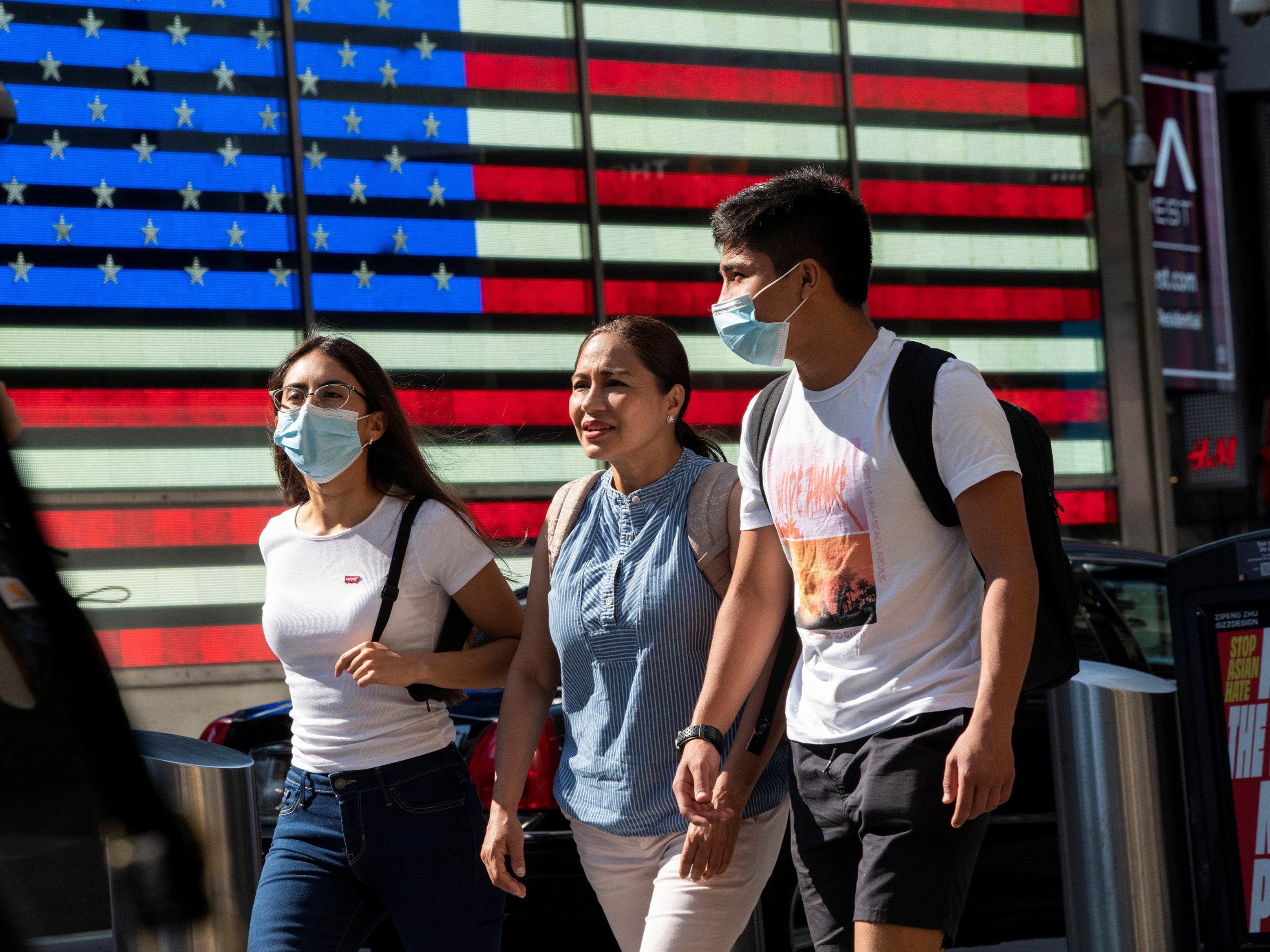 People wear masks around Times Square, as cases of the infectious coronavirus Delta variant continue to rise in New York City, New York