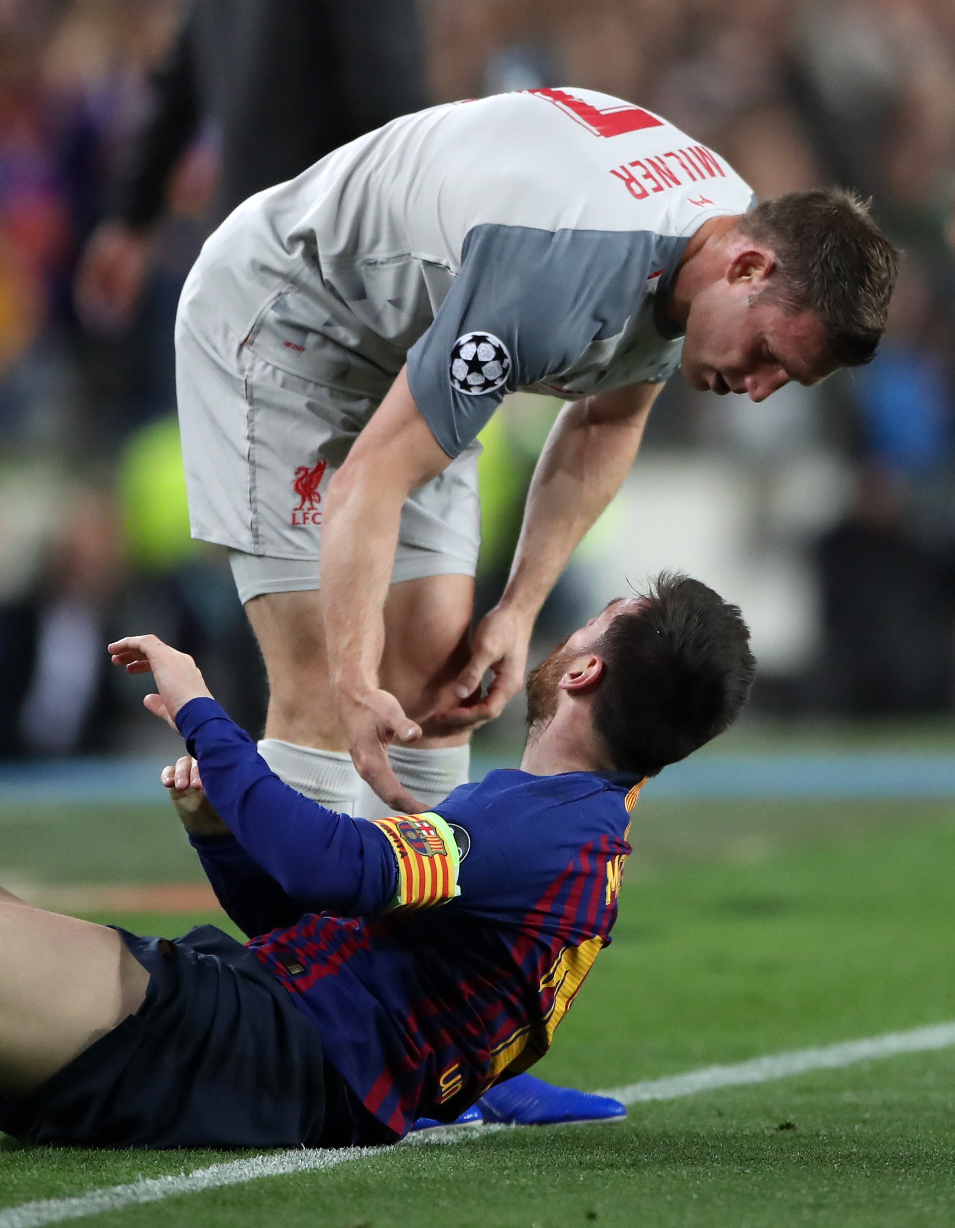 Milner offers Messi a hand during the Champions League semi-final first leg at the Nou Camp four years later (PA)