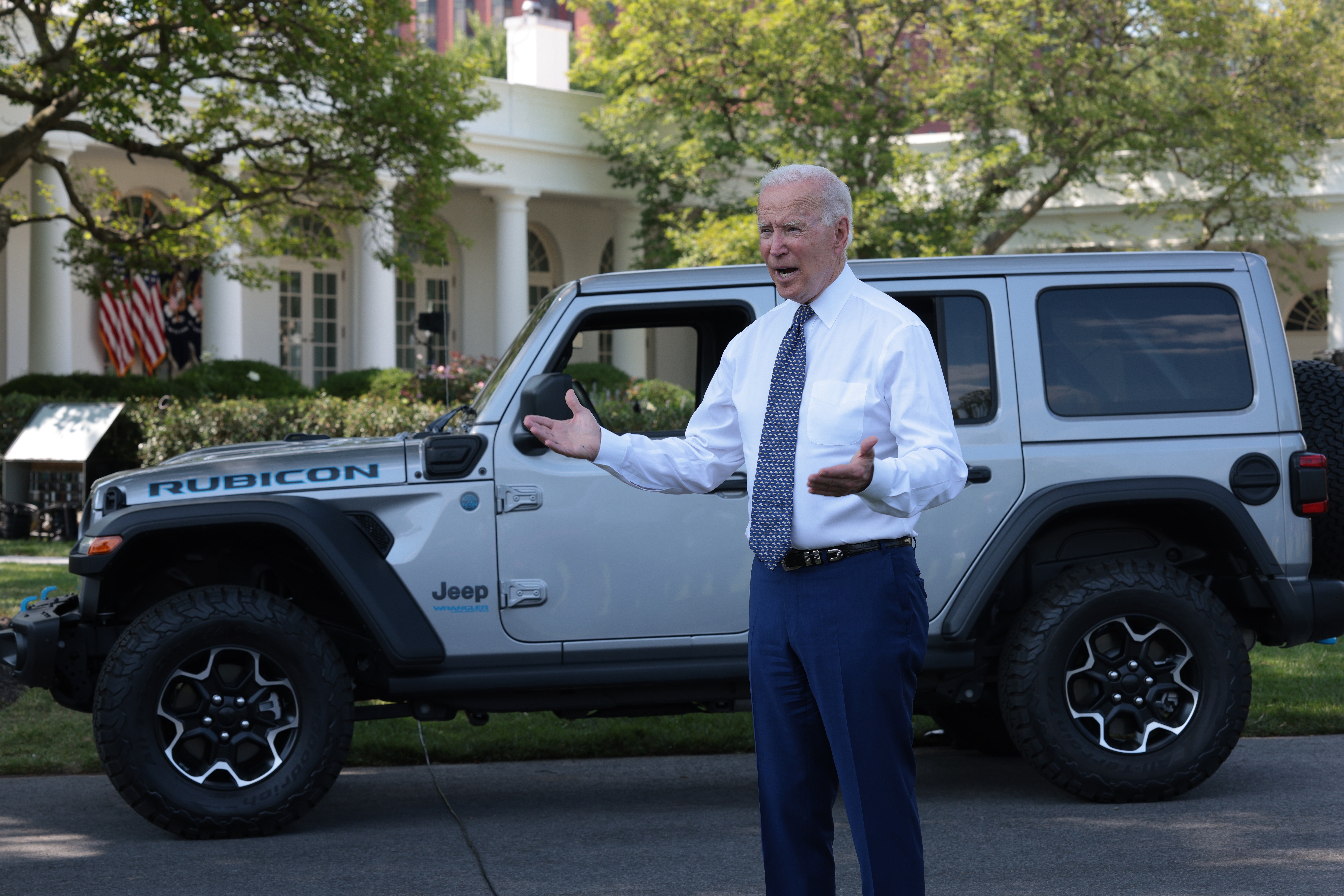 President Joe Biden answers questions from reporters after driving a Jeep Wrangler Rubicon Xe around the White House driveway following remarks during an event on the South Lawn of the White House 5 August 2021.