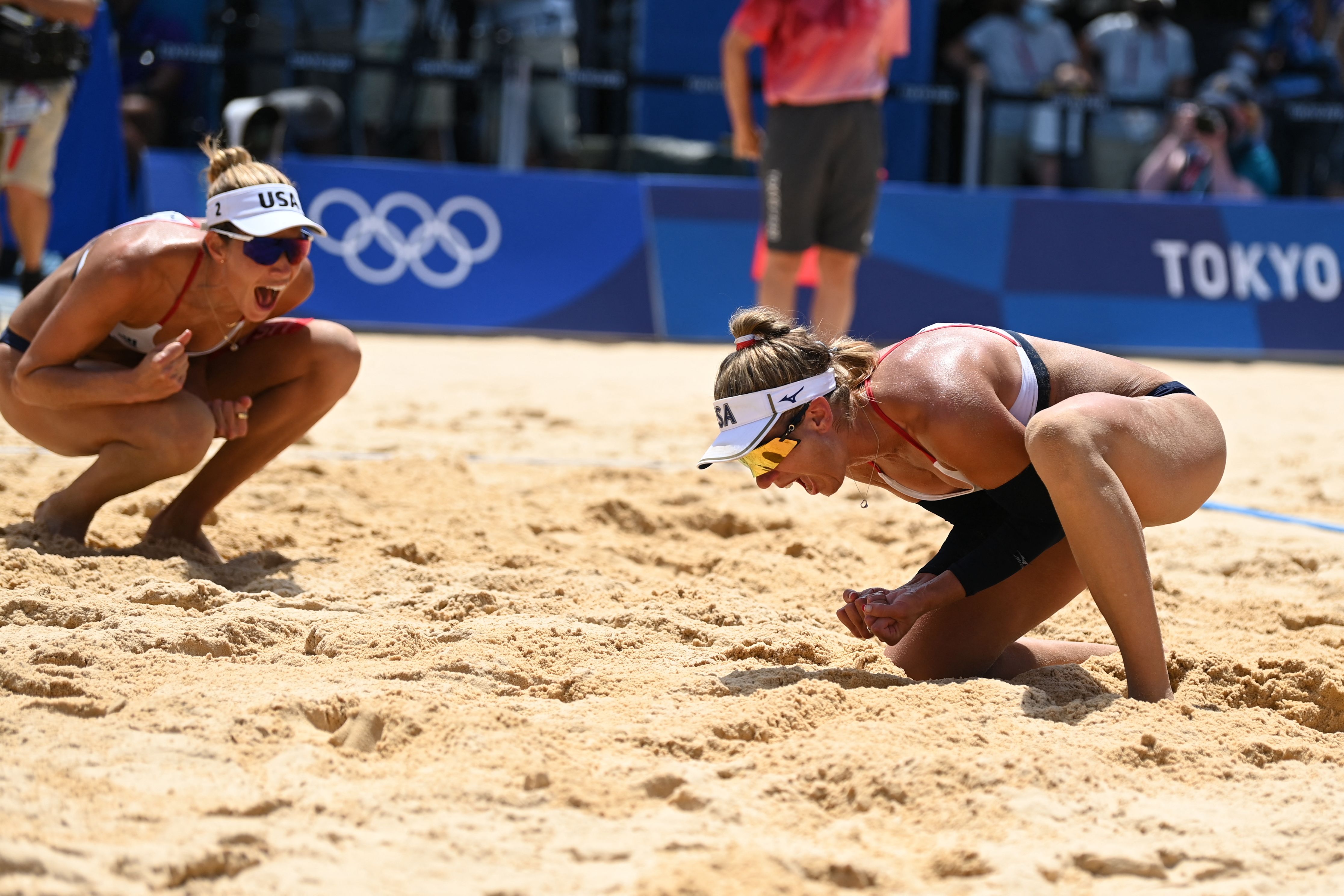 USA's Alix Klineman (L) and April Ross celebrate winning their women's beach volleyball final match between Australia and the USA during the Tokyo 2020 Olympic Games at Shiokaze Park in Tokyo on August 6, 2021.