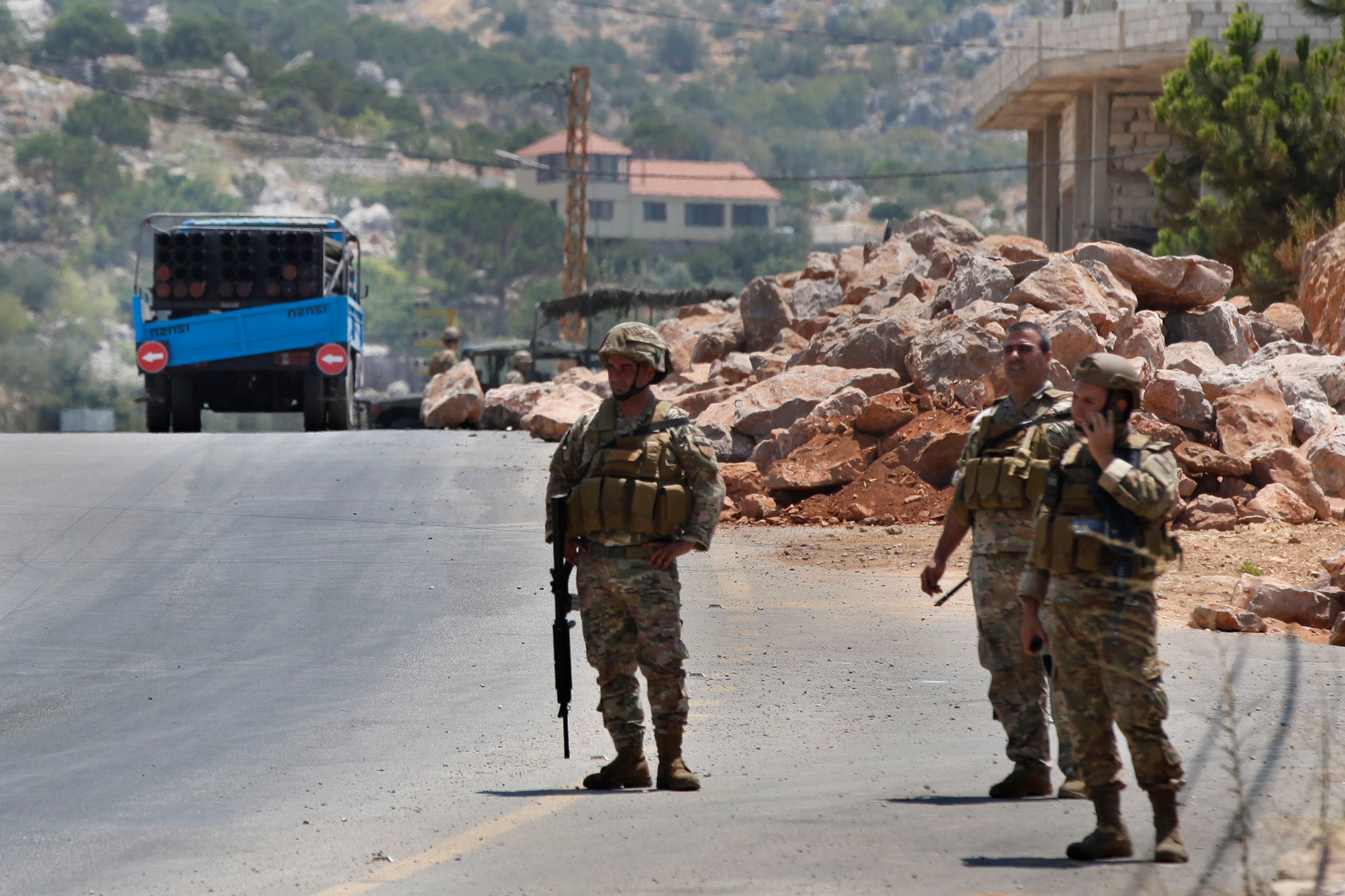 Lebanese army soldiers stand next to a rocket launcher placed on a pick-up truck that was used by Hezbollah to fire rockets near Israeli positions